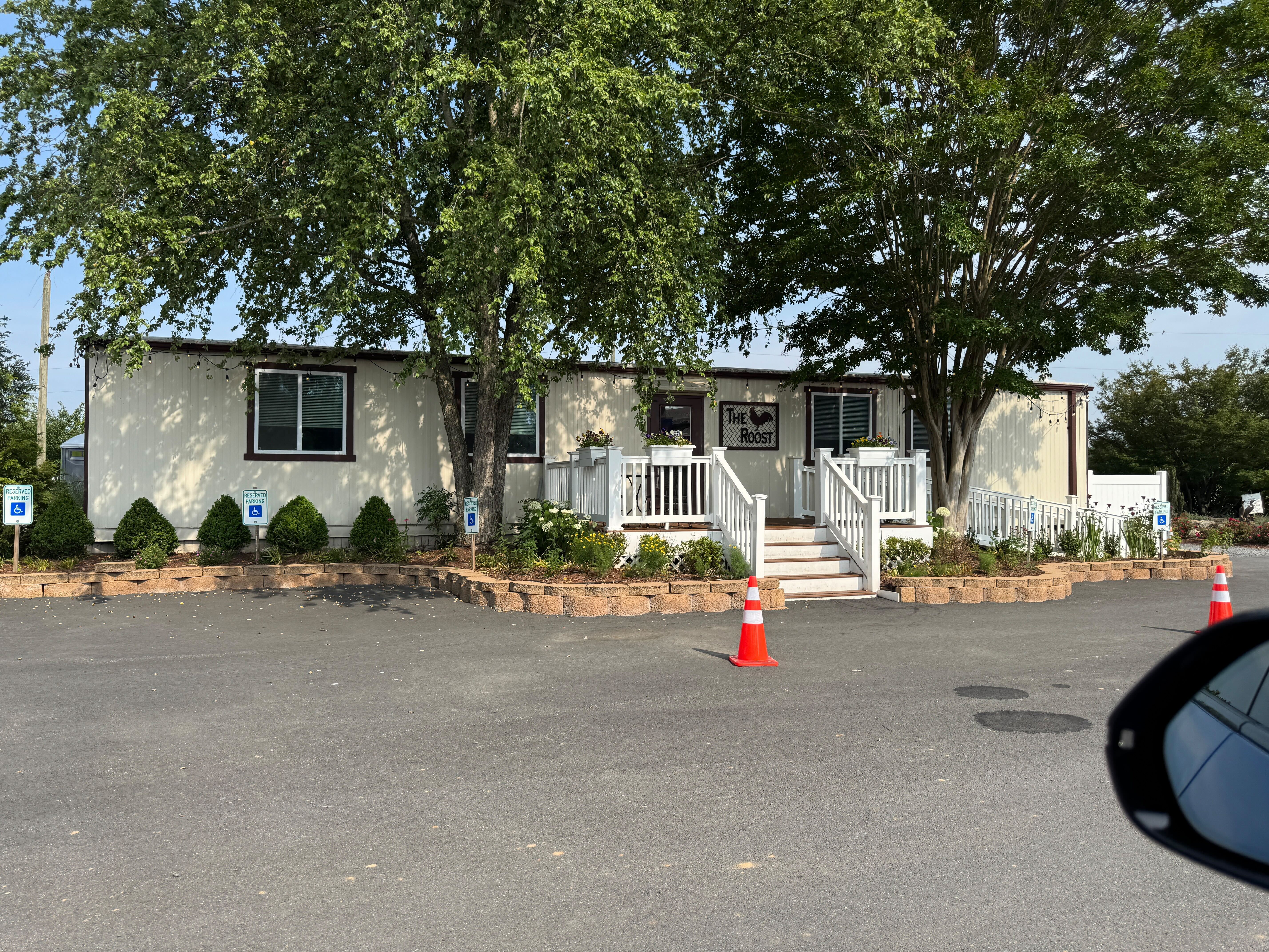 The exterior of The Roost at Farm Brewery in Haymarket, Virginia, showing the entrance to the building from the parking lot.