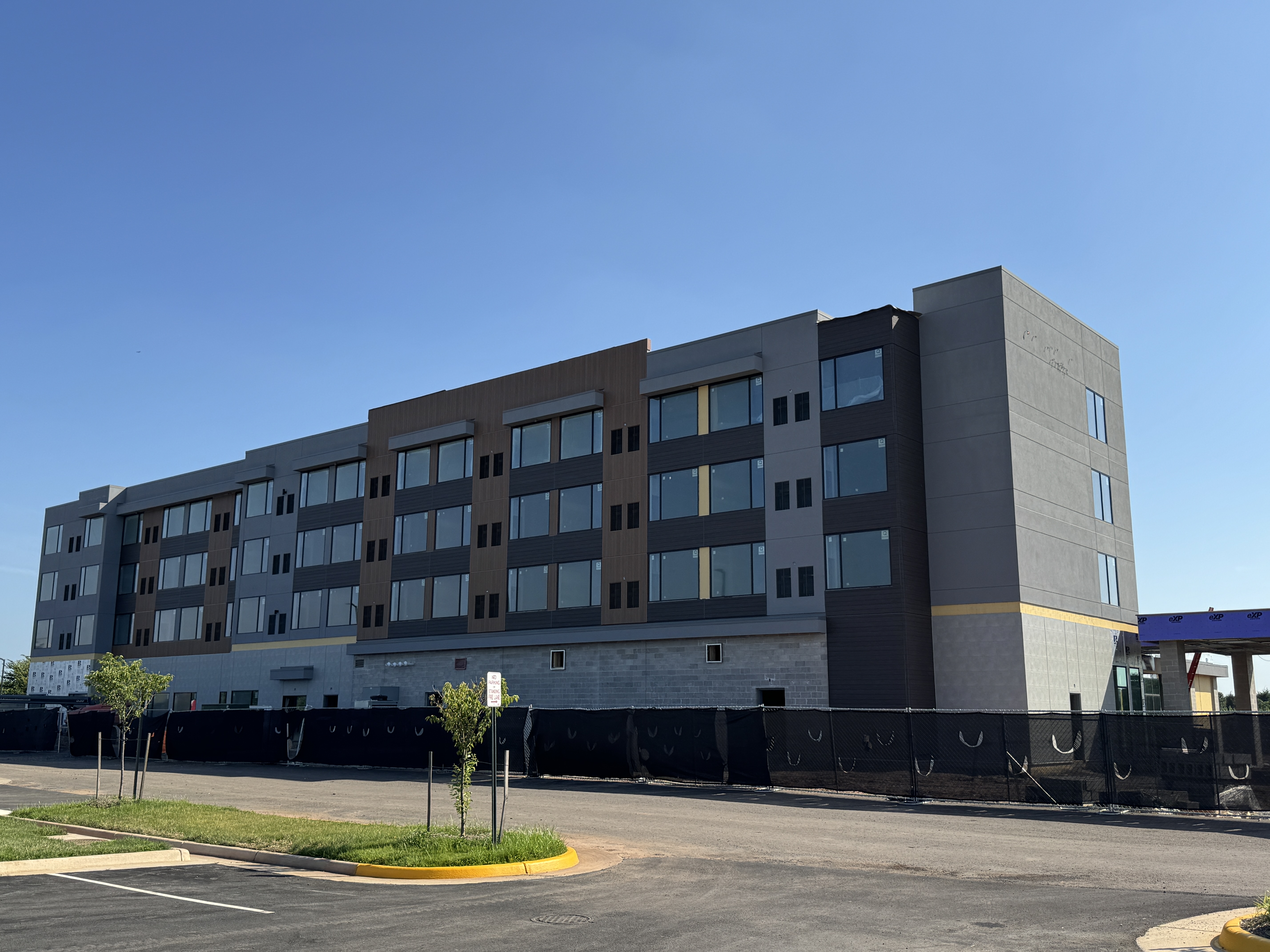 The modern exterior of the new Element Hotel under construction in Manassas, VA, viewed from the street on a sunny day.