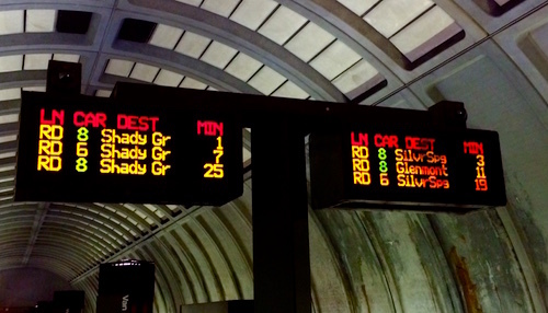 DC Metro subway train arriving at station with red signage