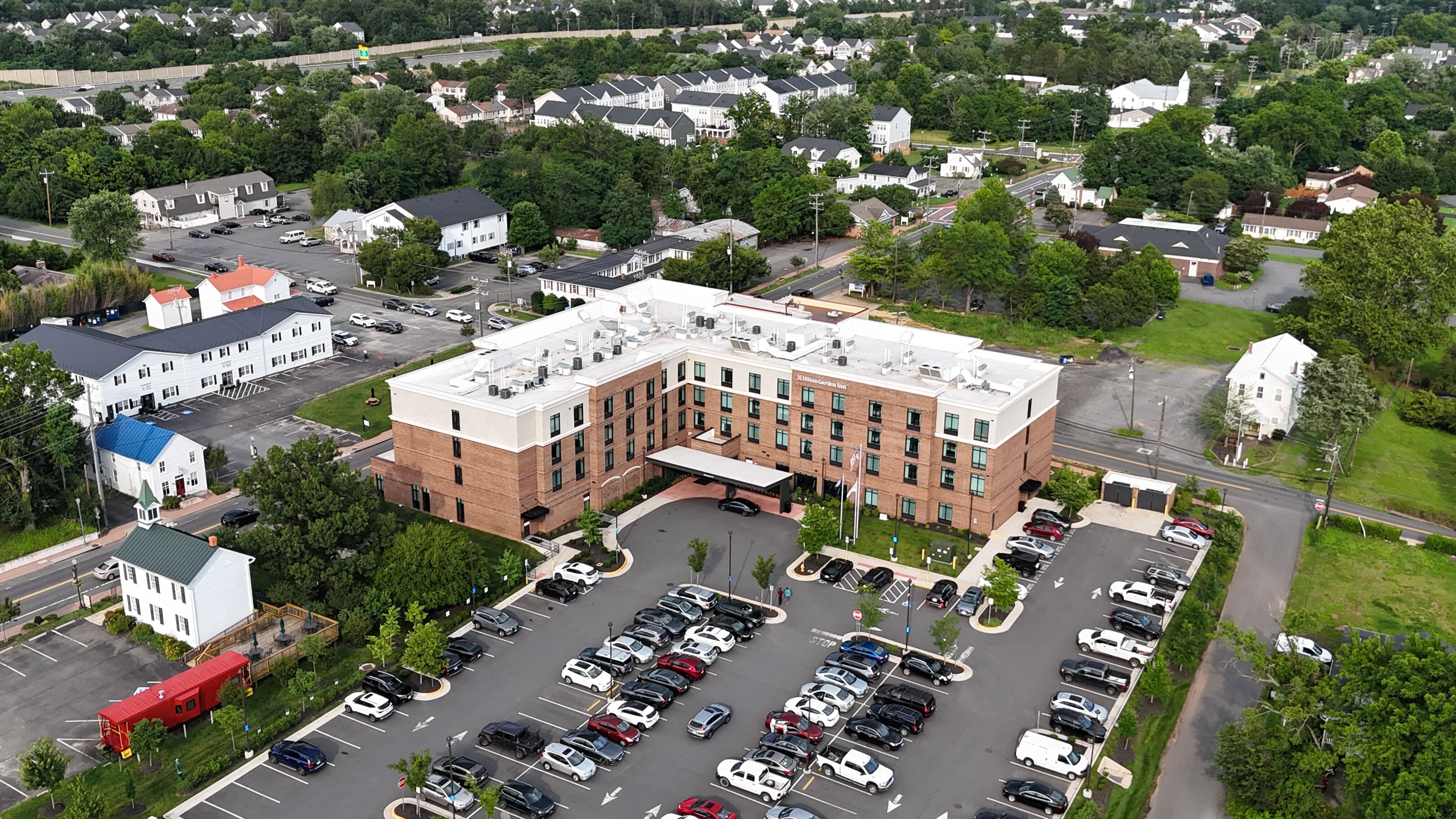 A drone shot looking over Interstate 66 at the Novant Health UVA Health System Haymarket Medical Center, surrounded by lush green trees.