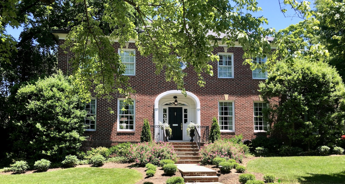 Classic brick colonial home with mature trees in a Northern Virginia suburb