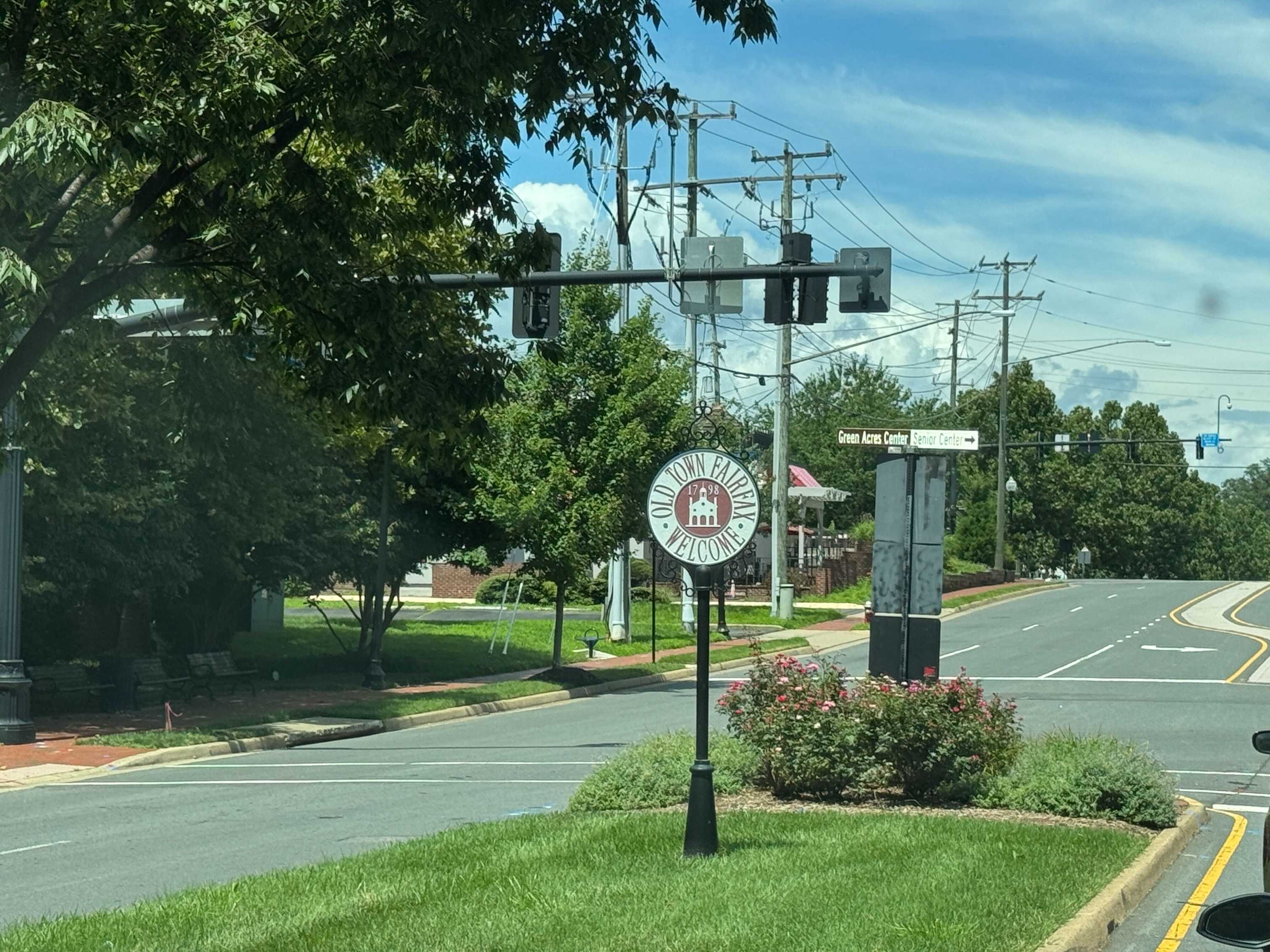 Old Town Fairfax welcome sign beside a landscaped street
