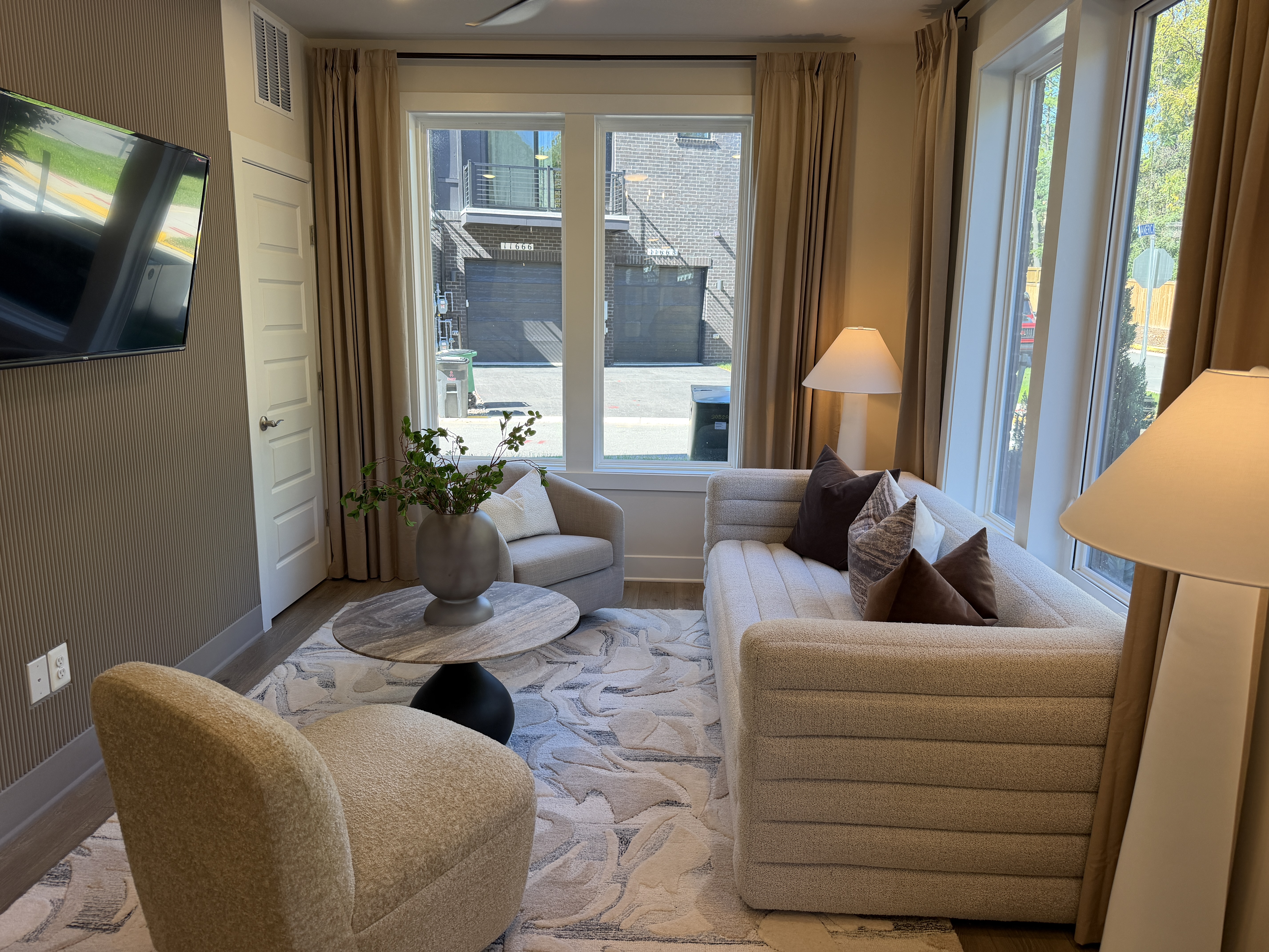 Sunset Station model sitting room with sofa, armchairs and large windows