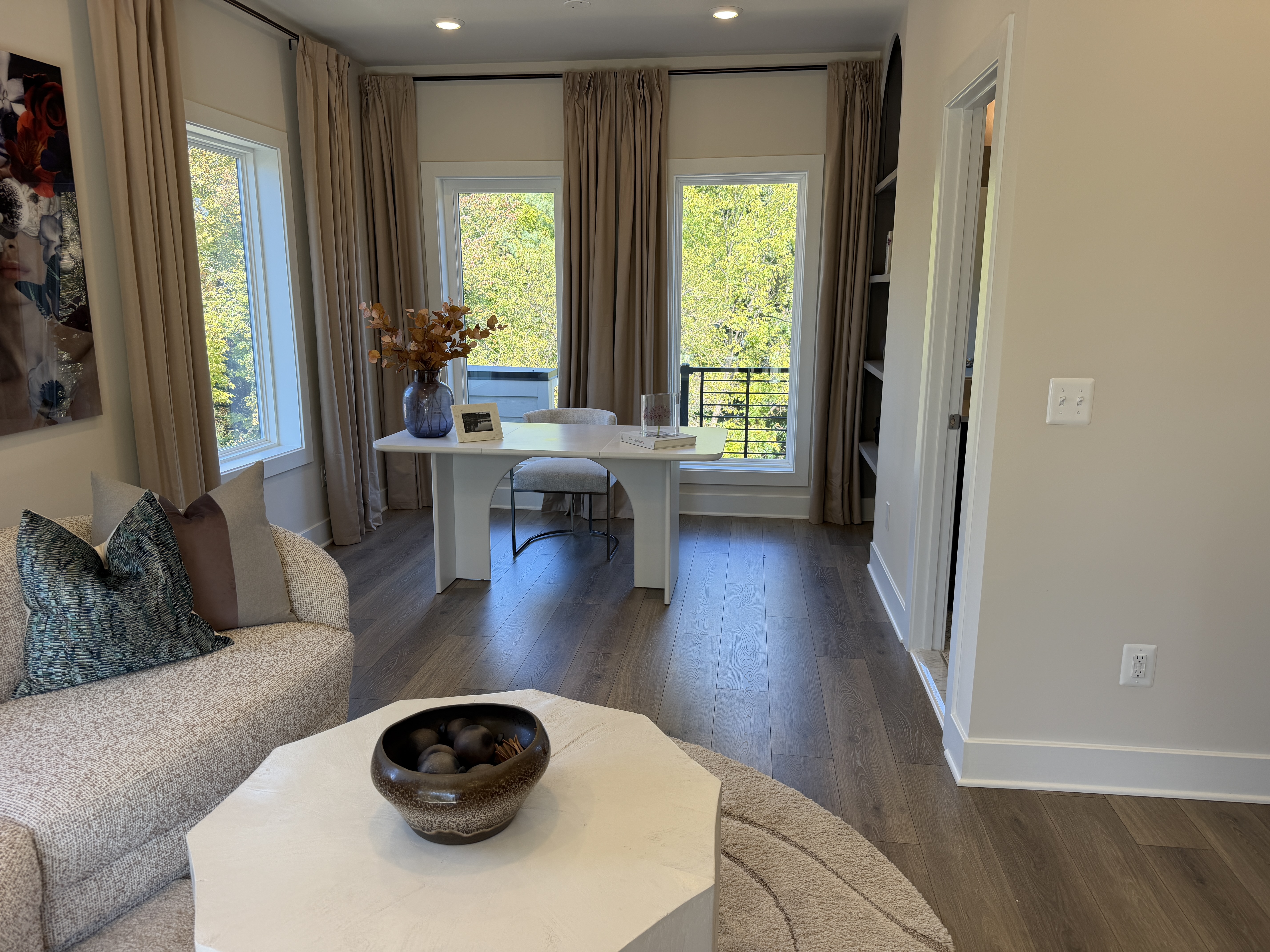 Sunset Station model room staged with a desk, sofa and tall windows