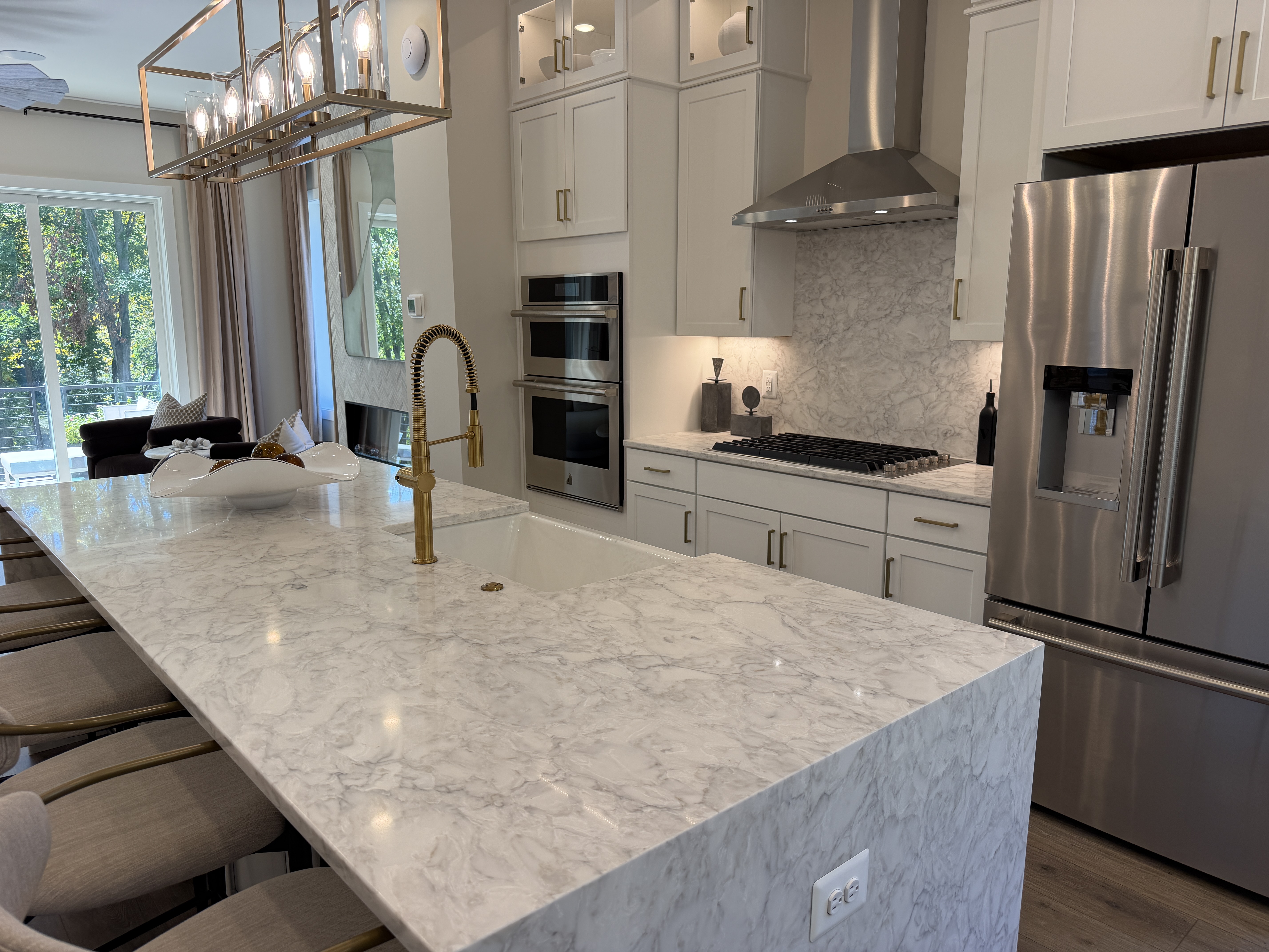 Sunset Station model kitchen with waterfall island, white cabinets and brass fixtures