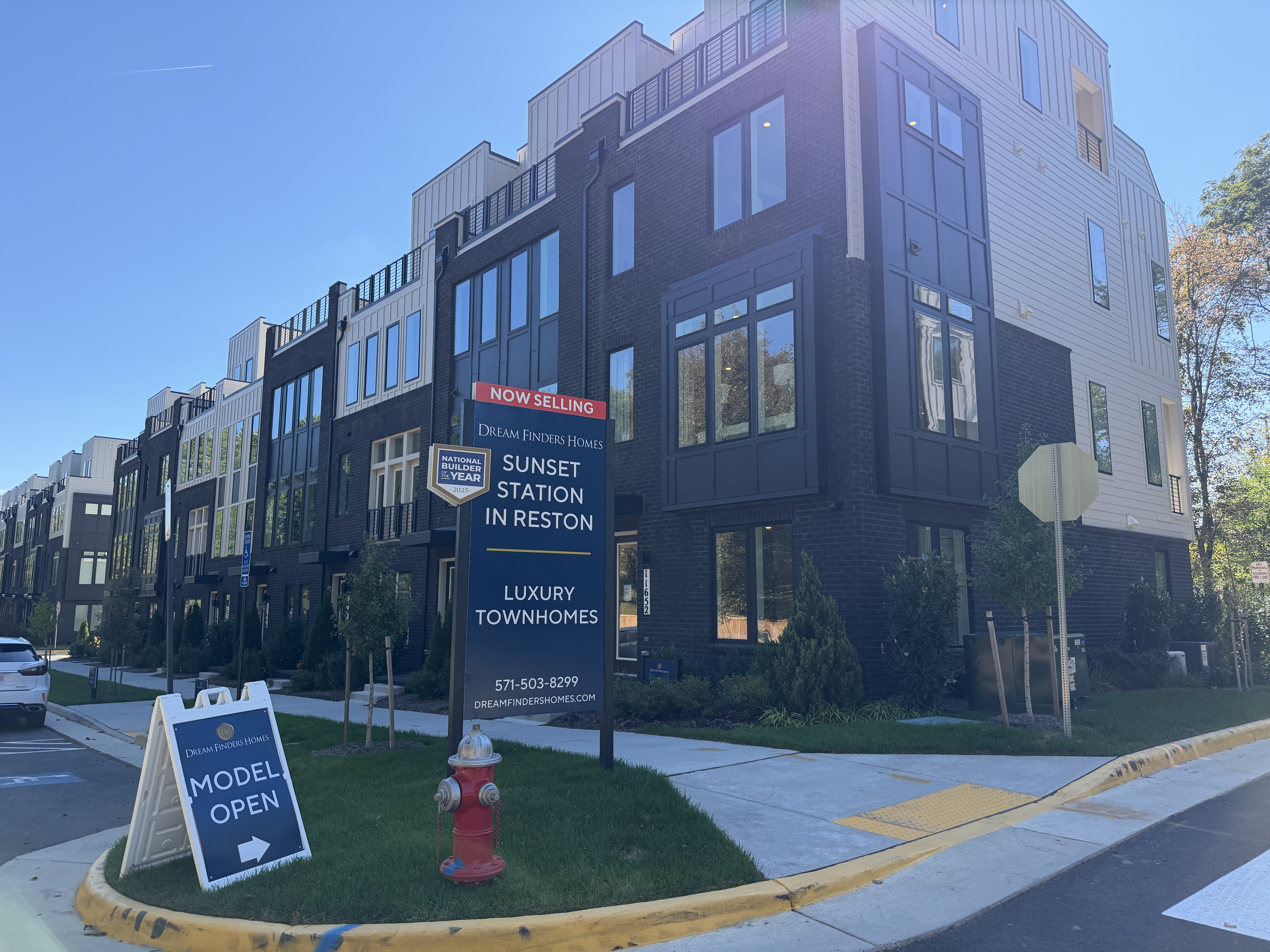 Sunset Station townhomes in Reston with brick exteriors and the community entrance sign; photo by Chris Colgan