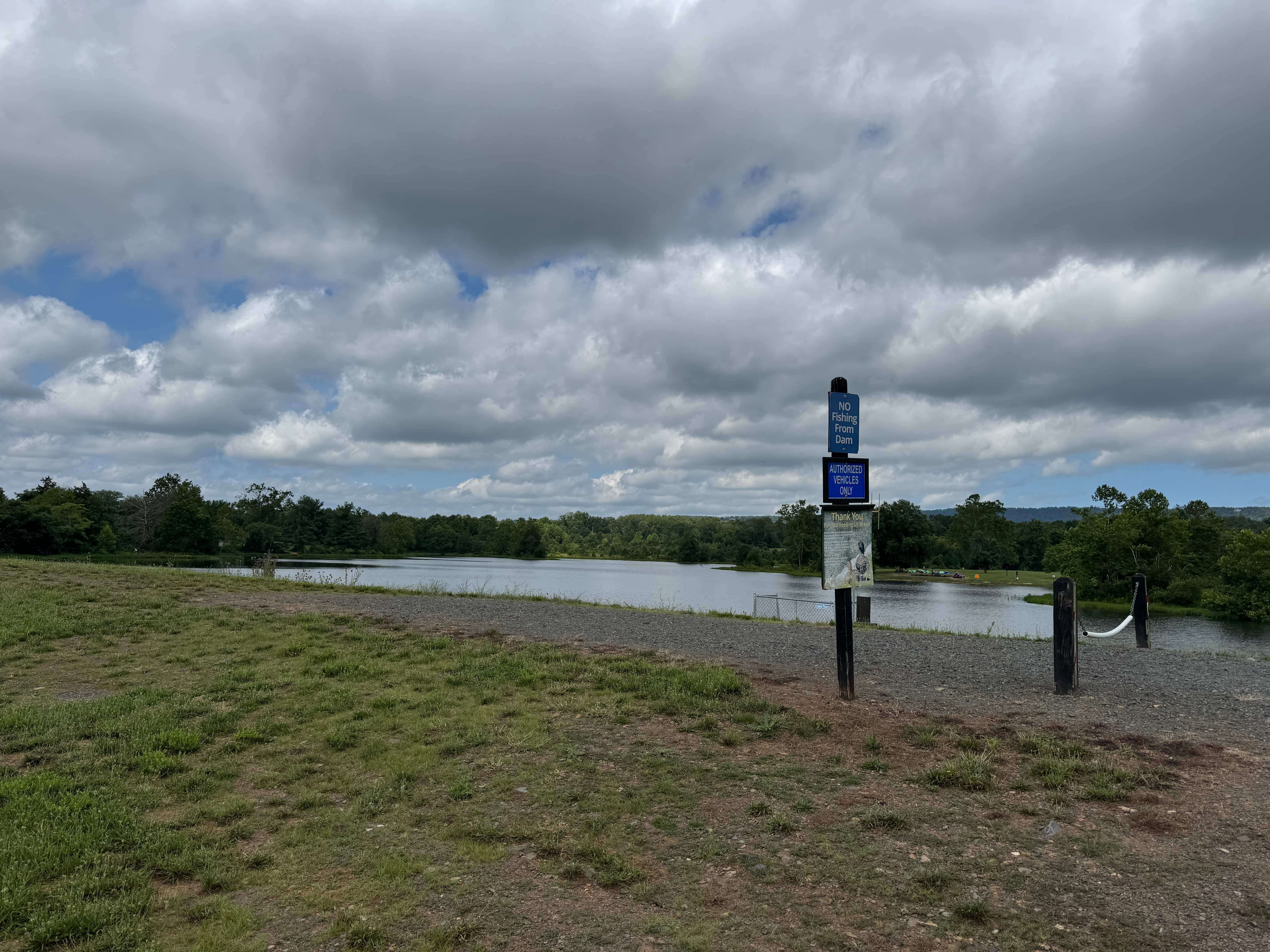 A wide, scenic view of the lake from the grassy dam at Silver Lake Park in Haymarket, a top outdoor photo spot in Northern Virginia.