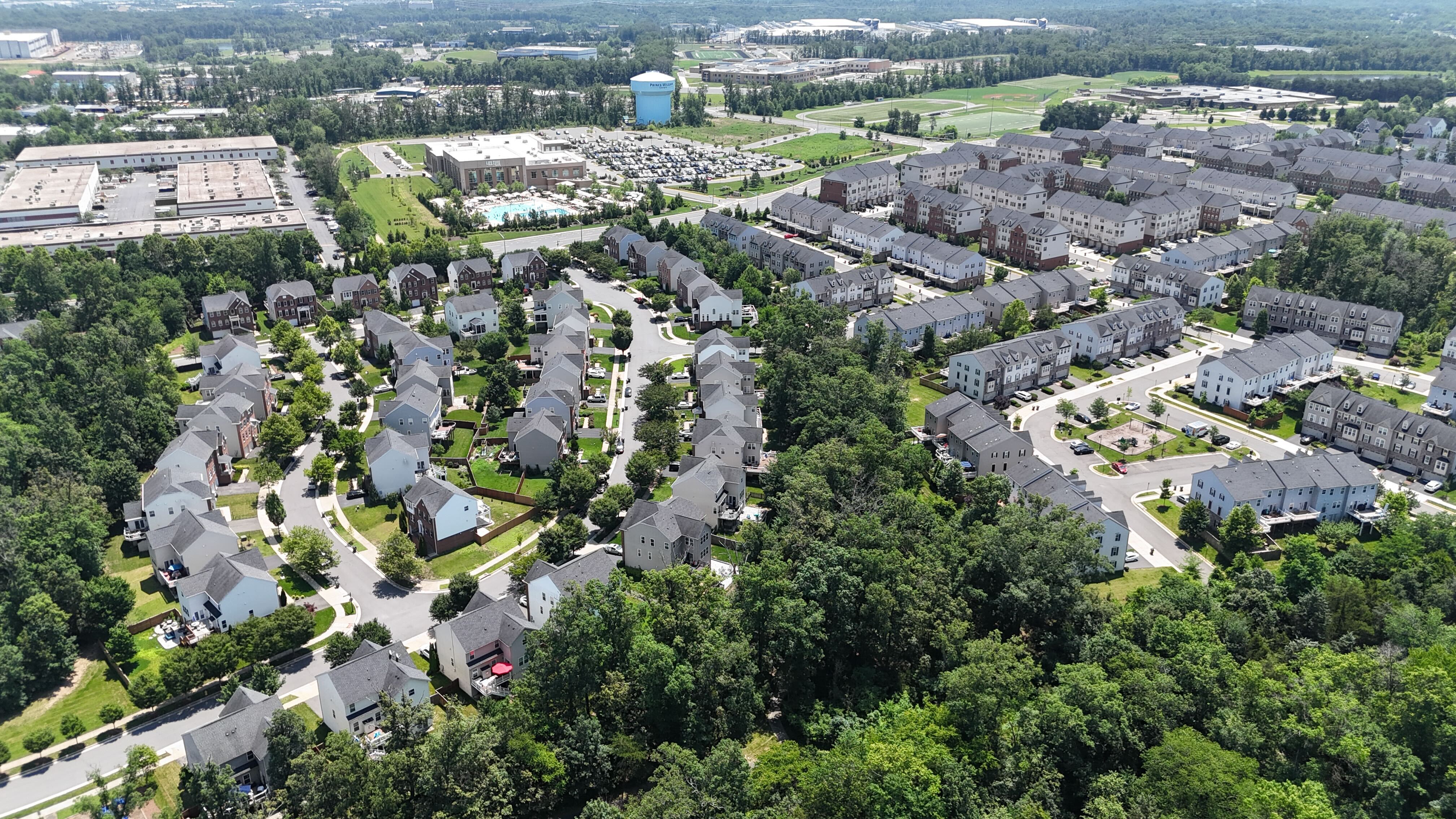 An aerial view of a residential neighborhood in Gainesville, Virginia, showing a mix of single-family homes and townhouses.
