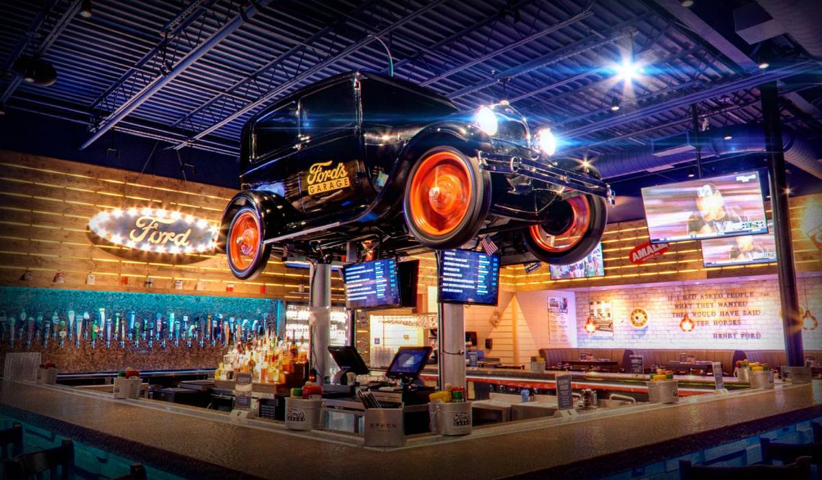 Exterior view of Ford’s Garage restaurant featuring vintage gas pumps, classic car signage, and a retro-industrial design that reflects its automotive-themed dining concept.