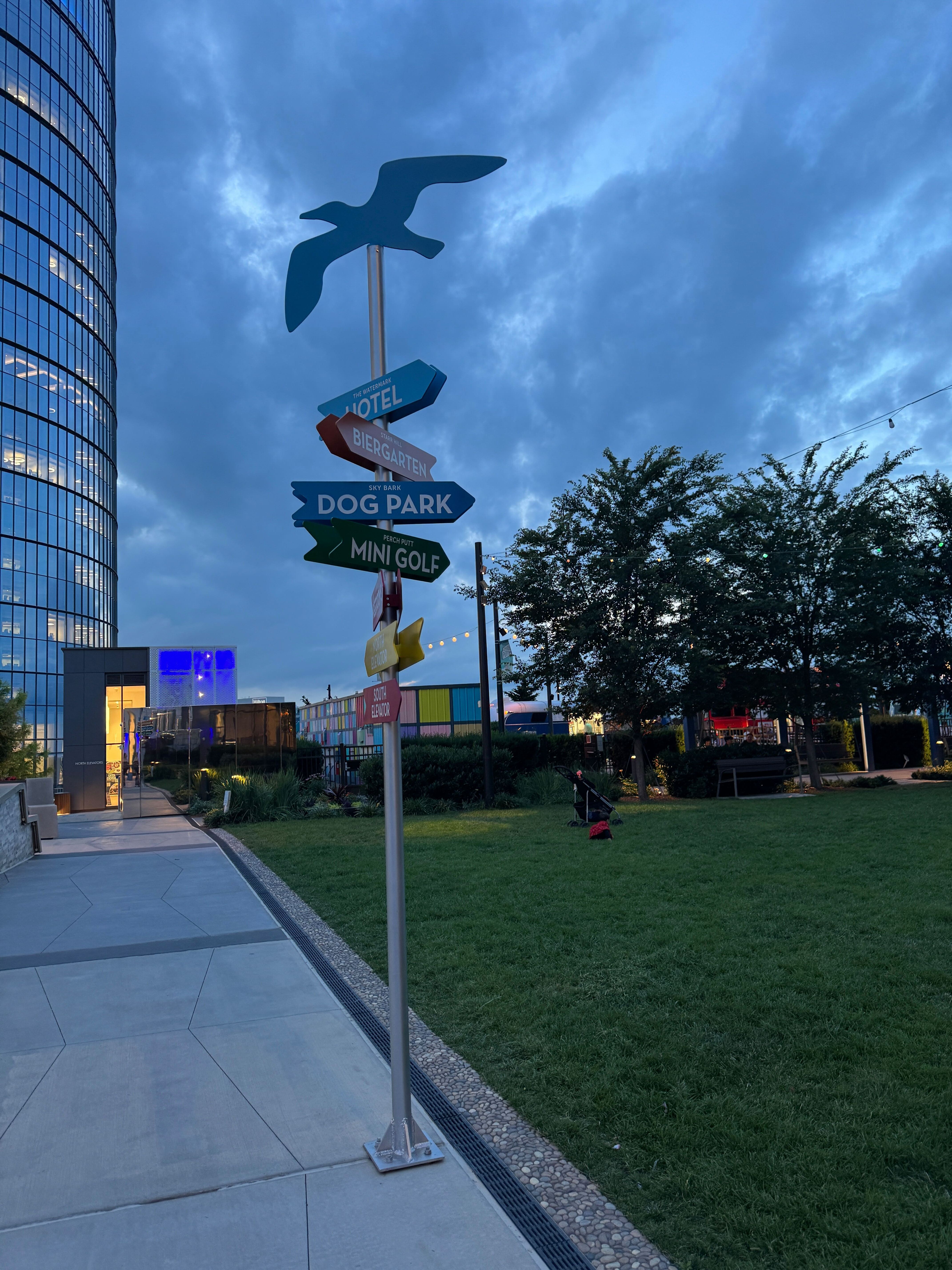 A colorful directional signpost at The Perch in Tysons, pointing to the venue's various amenities like the biergarten and dog park.