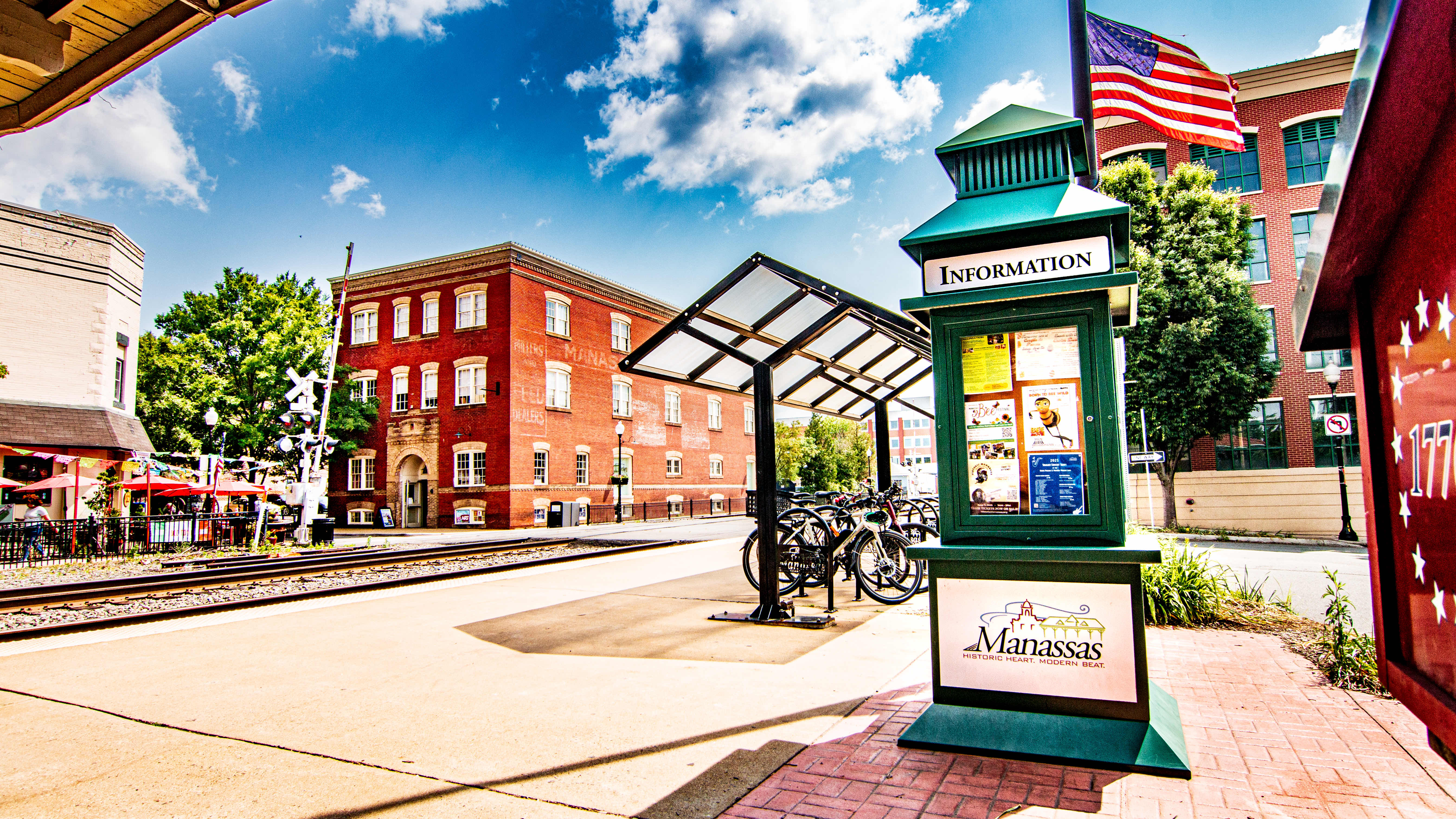 Old Town Manassas beside the train depot, with historic brick buildings, tracks and the visitor information sign.