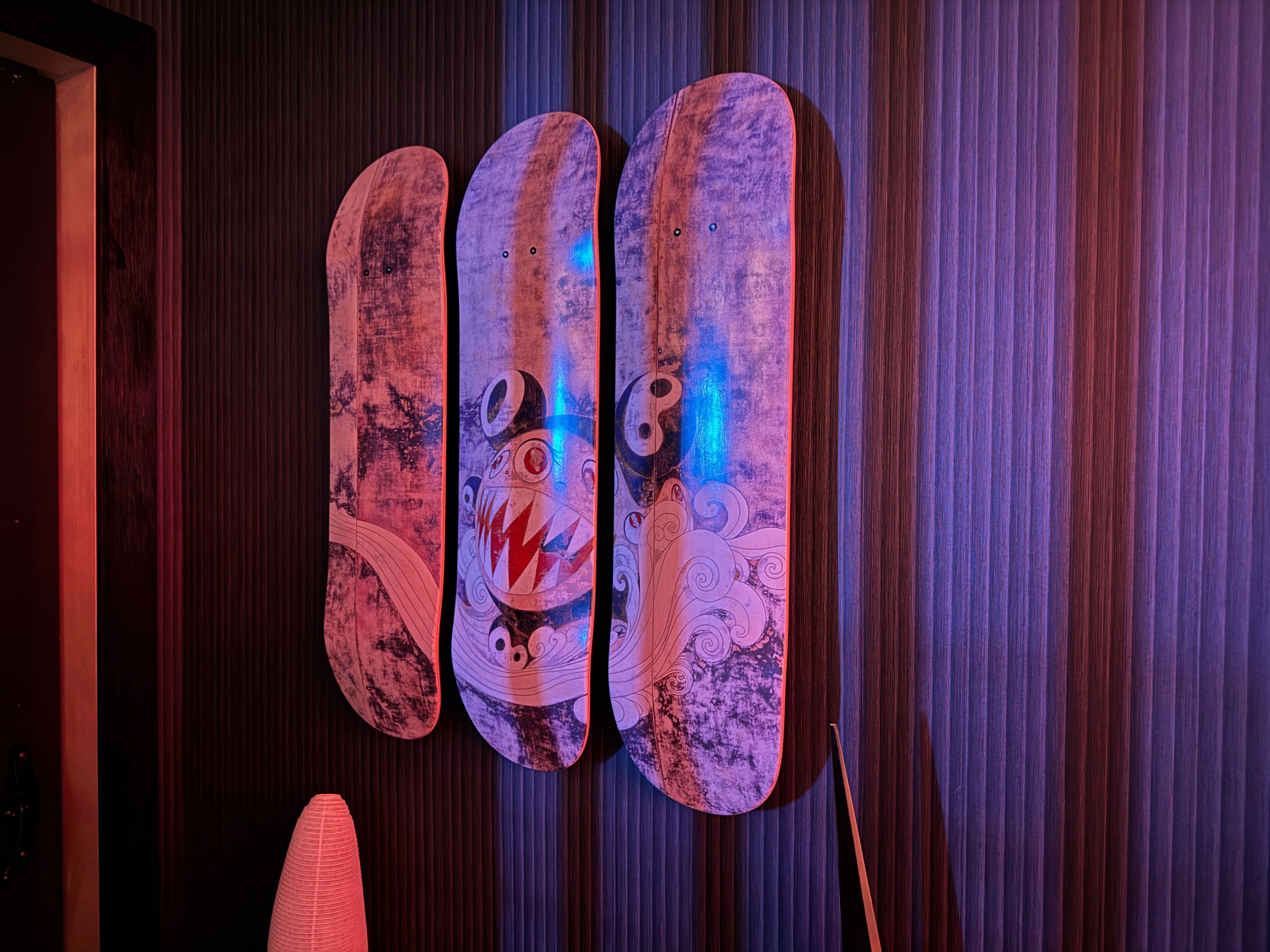 Modern wall decor at the Naisō Room in Tysons, showcasing a unique art piece depicting a monster face across three vertically mounted skateboard decks.