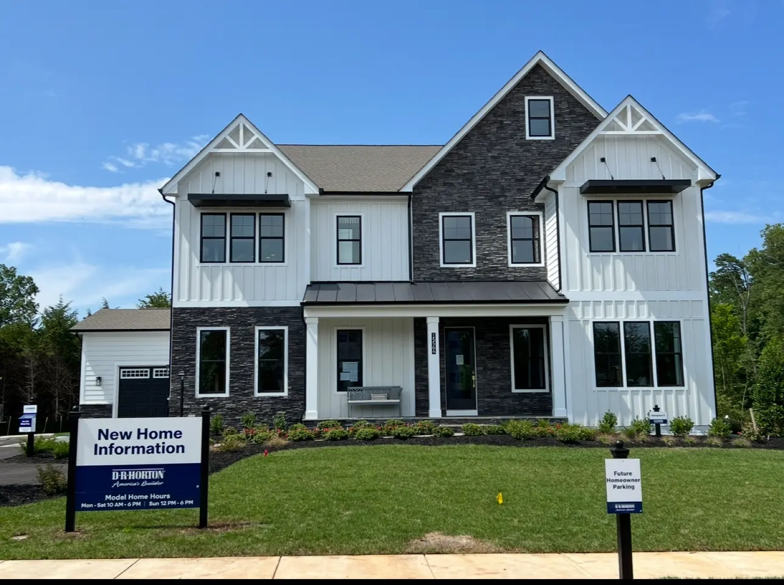 White siding and stone exterior of a model home in Haymarket, Virginia