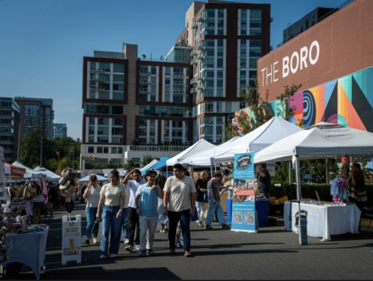Outdoor market with vendor tents and visitors at The Boro in Tysons, Virginia