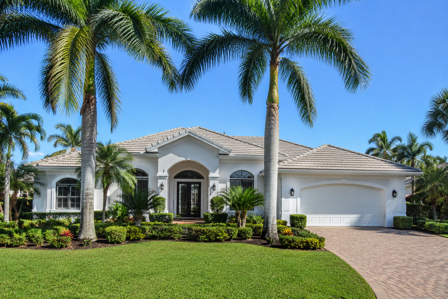 Well-maintained Florida home with palm trees and tropical landscaping prepared for summer and hurricane season.