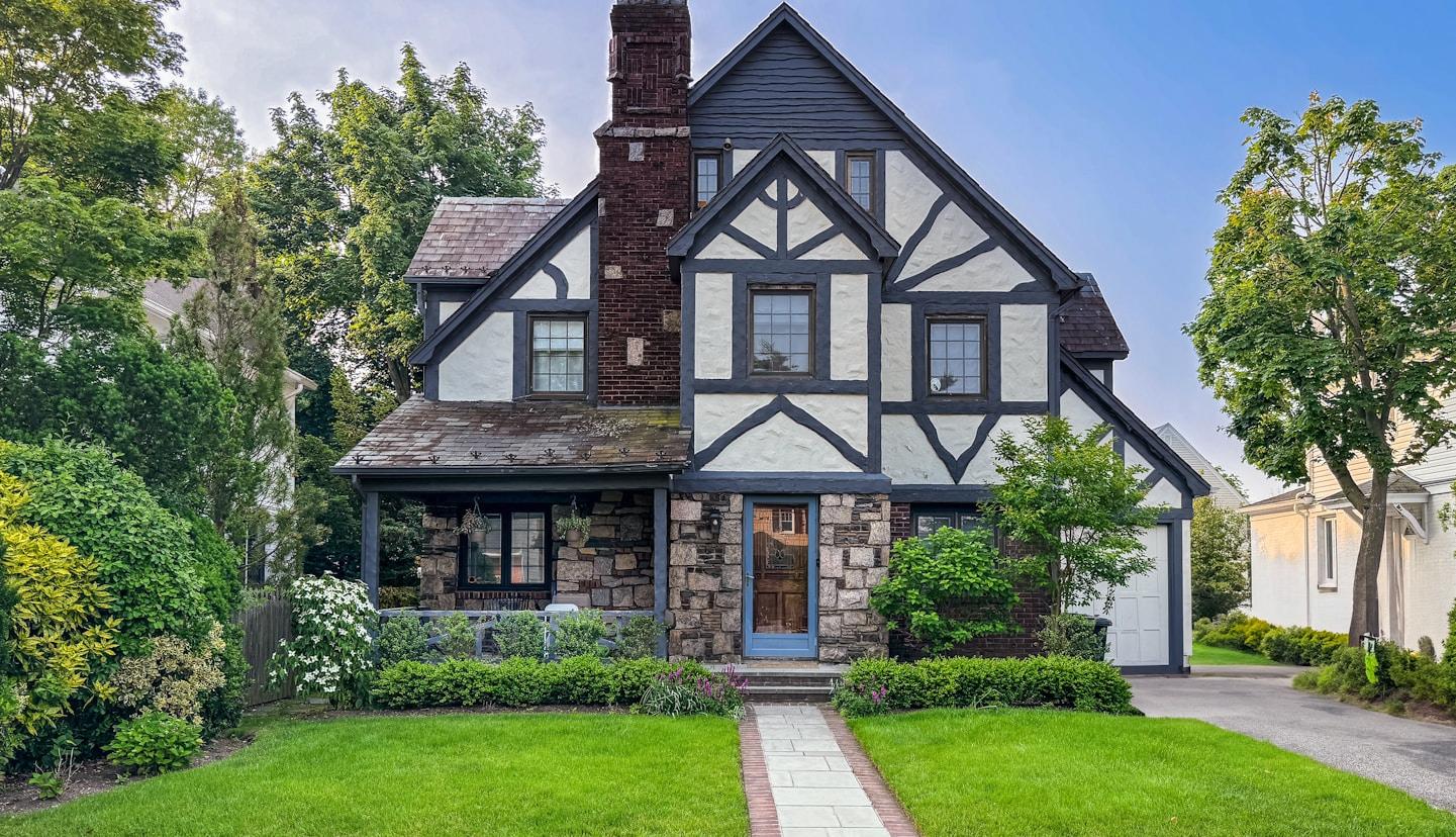 Charming two-story house exterior with manicured lawn, representing homes for sale in Huntsville, AL