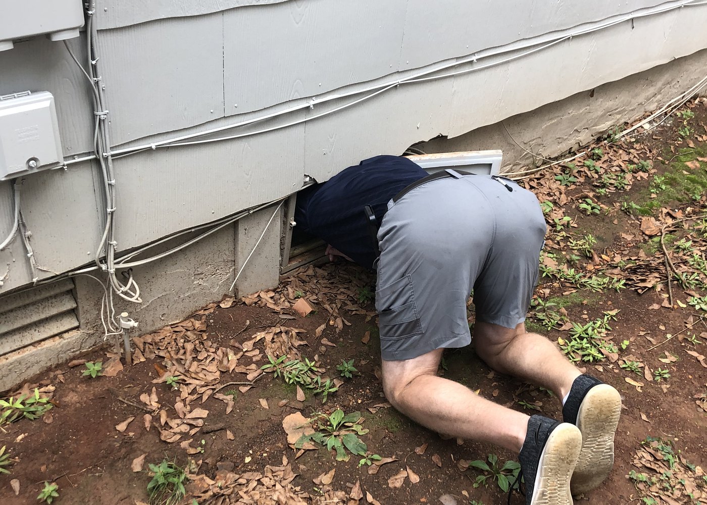 A home inspector entering the crawlspace of a house in Huntsville, Alabama