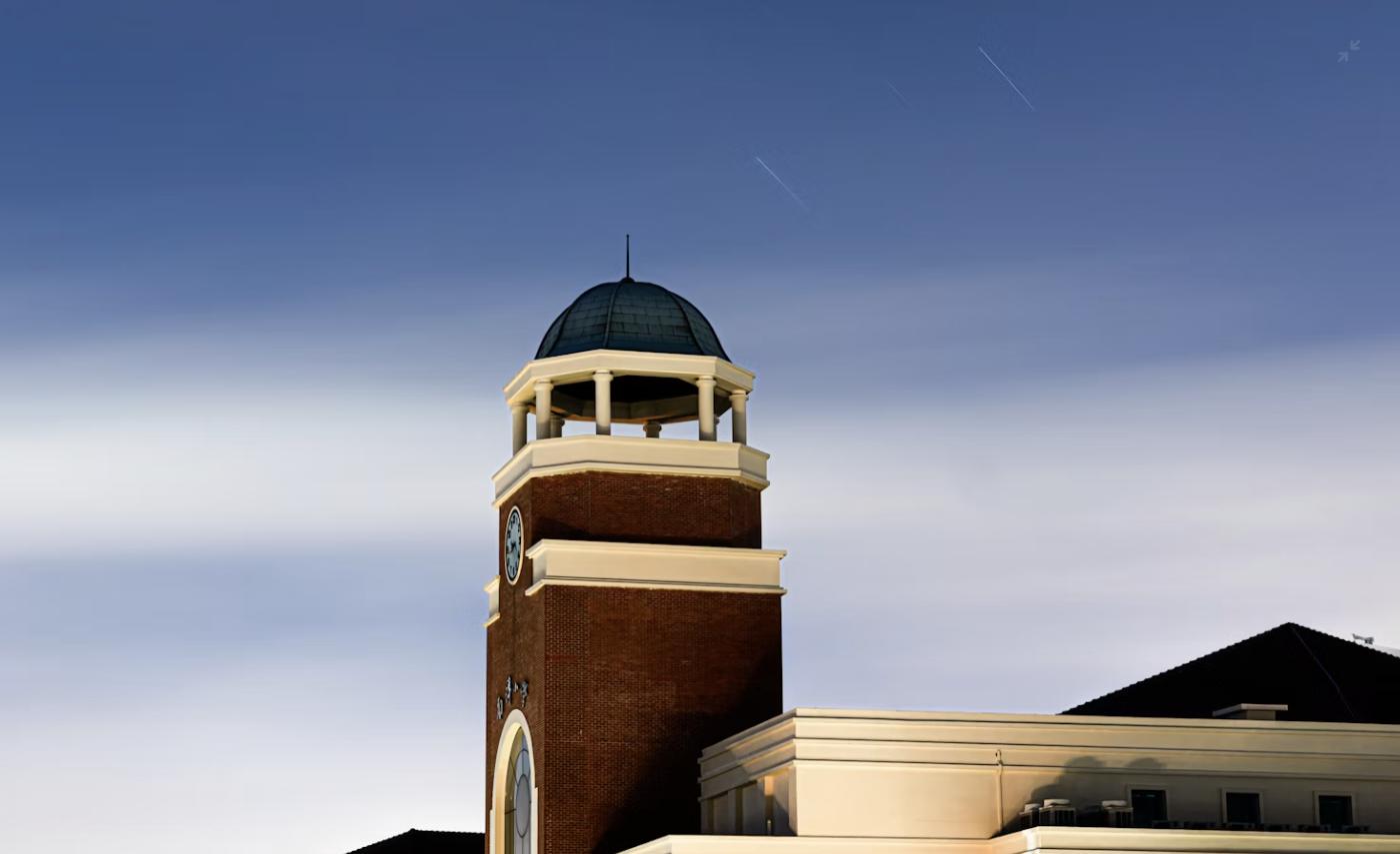 School building exterior with a clock tower, representing the range of public and private school options for families moving to Huntsville and Madison, AL