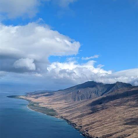 Aerial view of Maui coastline and mountains, showcasing the island’s oceanfront real estate potential.