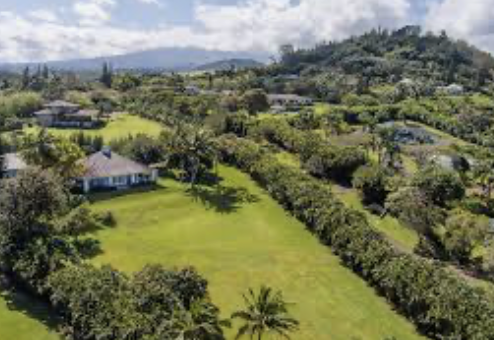 Aerial view of a lush country home in Haiku on Maui's North Shore surrounded by tropical greenery and mountain views