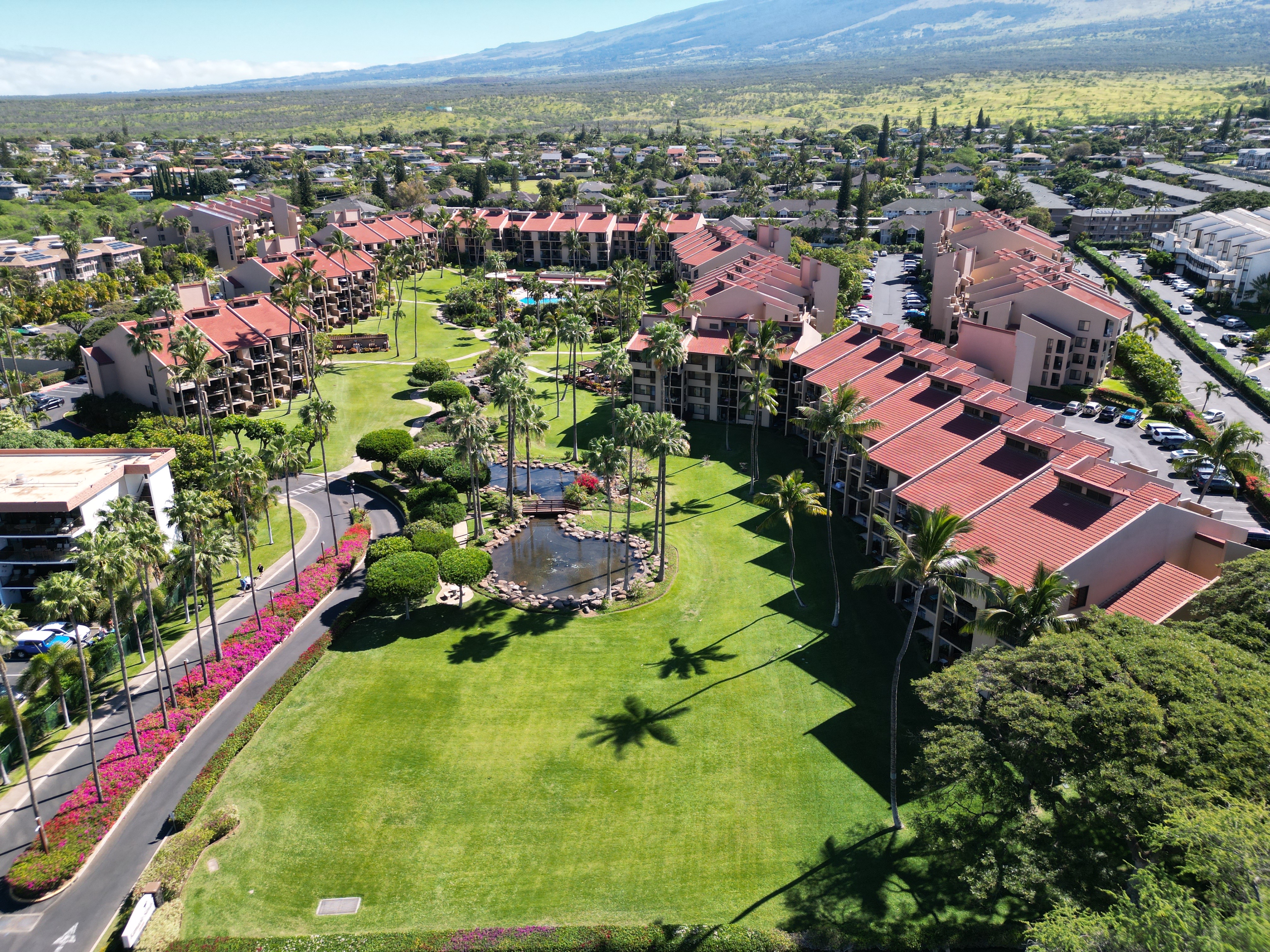 Condo complex in Maui representing one of the best neighborhoods to buy a home in 2025, with palm trees, tropical design, and mountain backdrop.