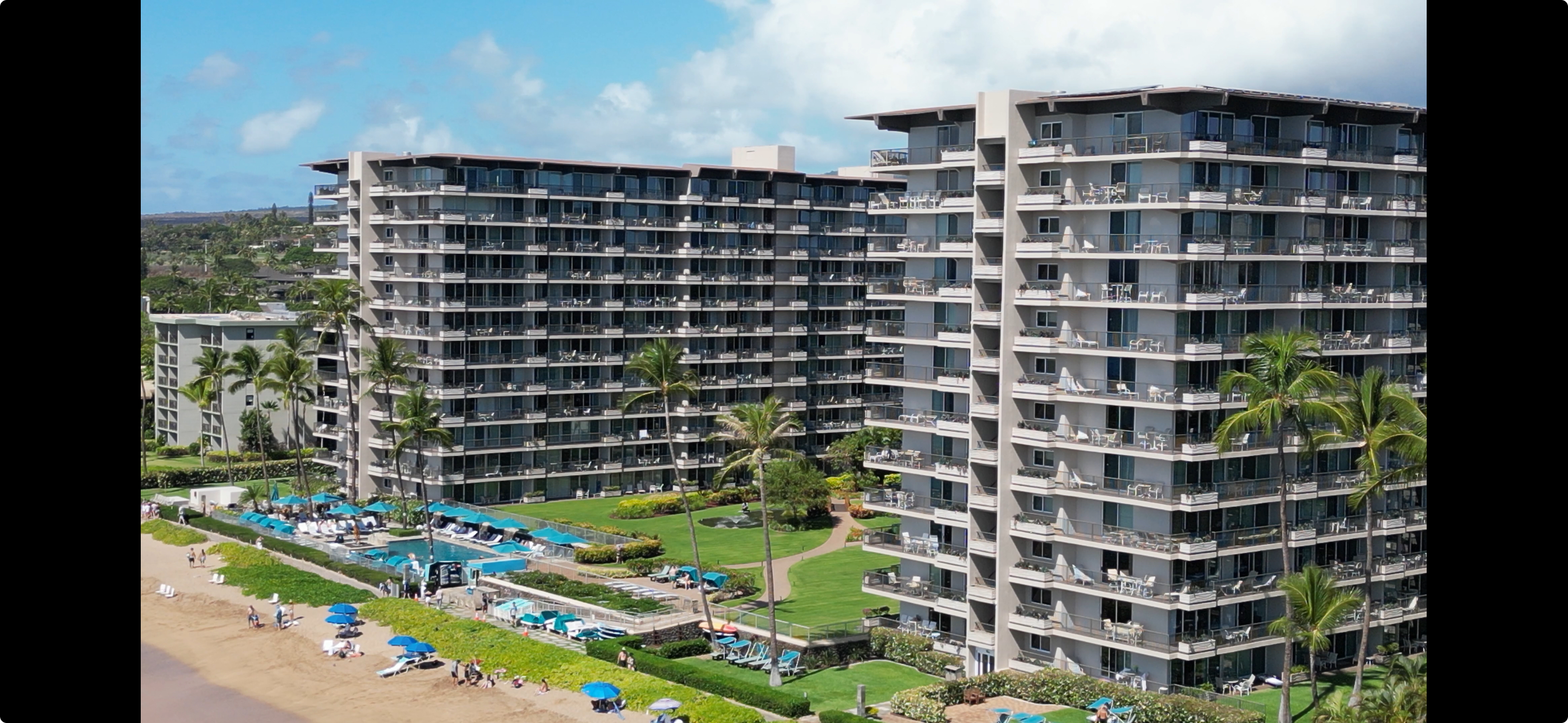 Oceanfront view of The Whaler condominium resort on Kāʻanapali Beach, Maui, with lush landscaping and direct beach access.
