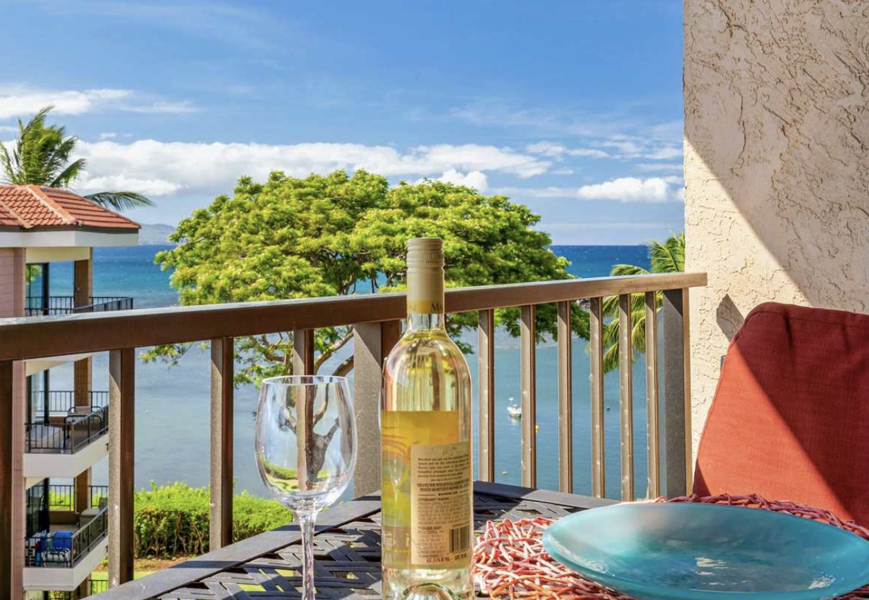 Oceanfront view of Maalaea Mermaid condo in Maalaea Maui with palm trees and blue water