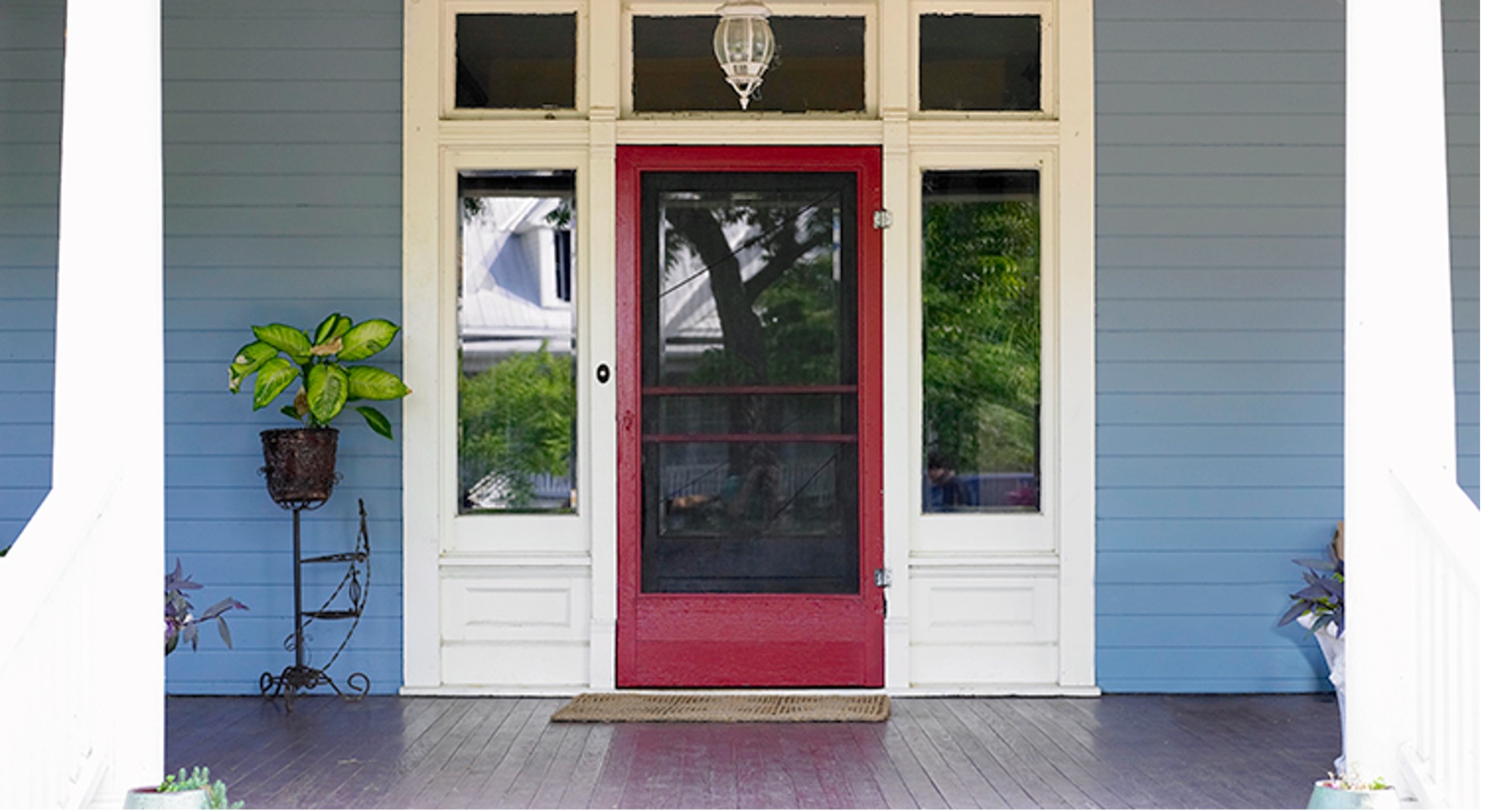 Front door of blue house with red screen door