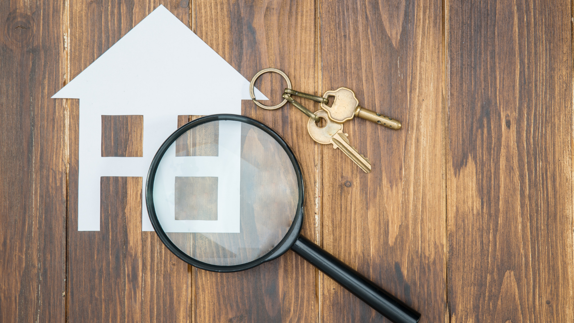 Magnifying glass over house and keys