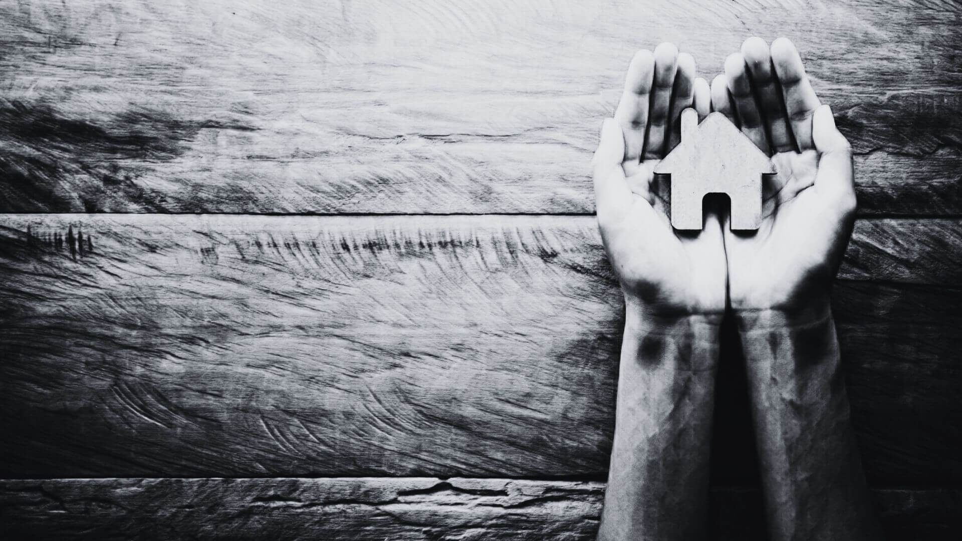 Hands holding a tiny home