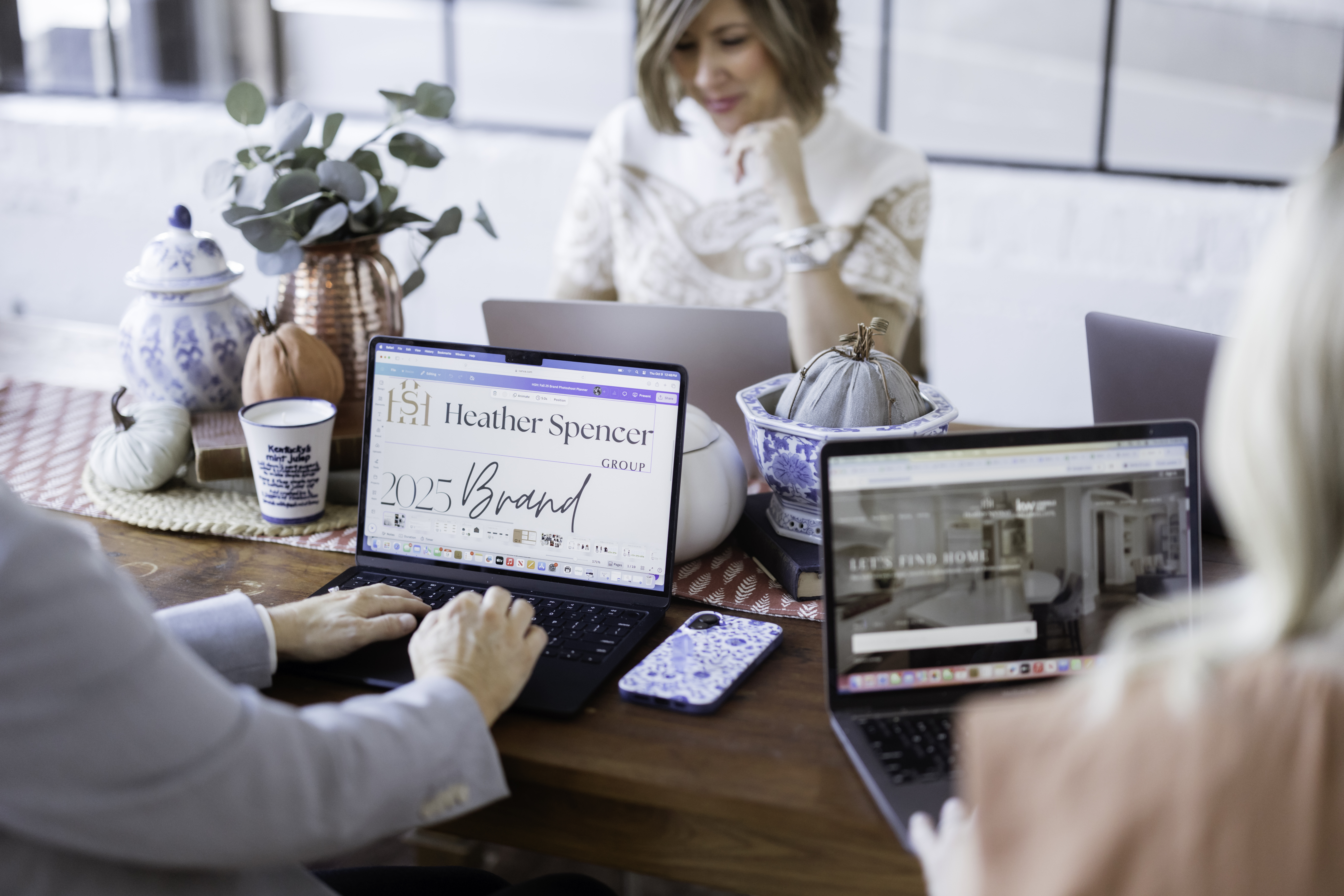 Heather Spencer Group team working on brand strategy and marketing planning with laptops at a table in Louisville, Kentucky.