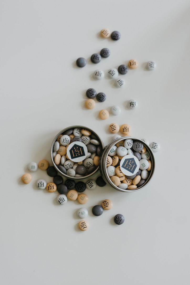 Branded client gift tins with logo in neutral colors representing real estate branding ideas and marketing materials