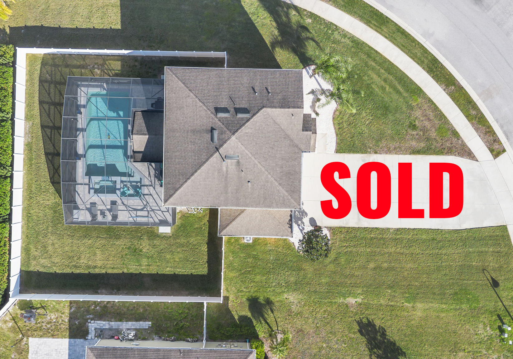 overhead of home with pool and the word sold on the driveway