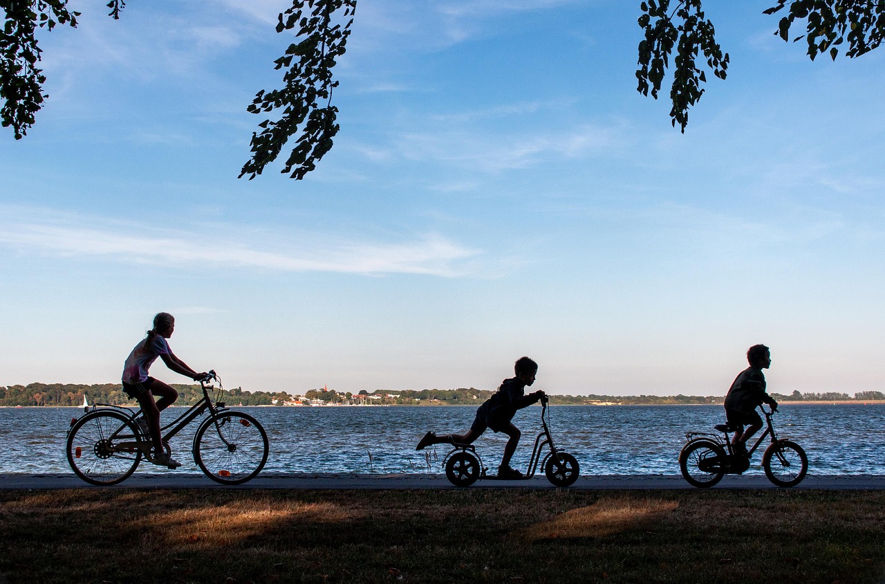Family cycling along a paved waterfront trail in Central Florida, representing active outdoor living near popular biking trails in West Volusia and Seminole County.
