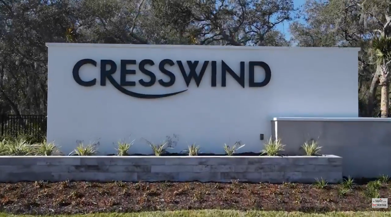 Entrance monument sign for Cresswind DeLand, a 55+ active adult community in DeLand, Florida, surrounded by landscaped greenery and mature oak trees.