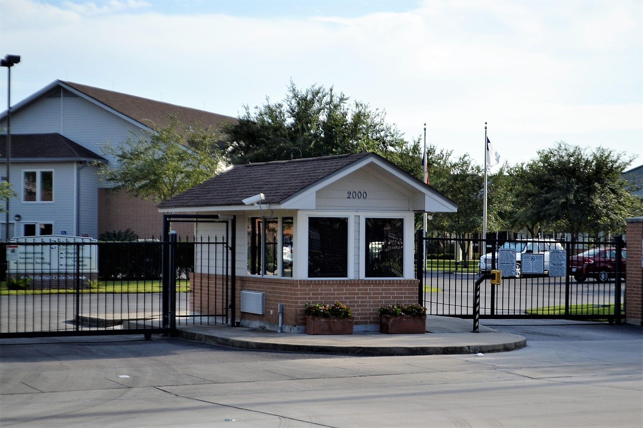 Guardhouse entrance to a gated residential community featuring a security gate, keypad access, and controlled entry lanes, illustrating privacy and restricted access in North Orlando neighborhoods like DeLand and Lake Mary.