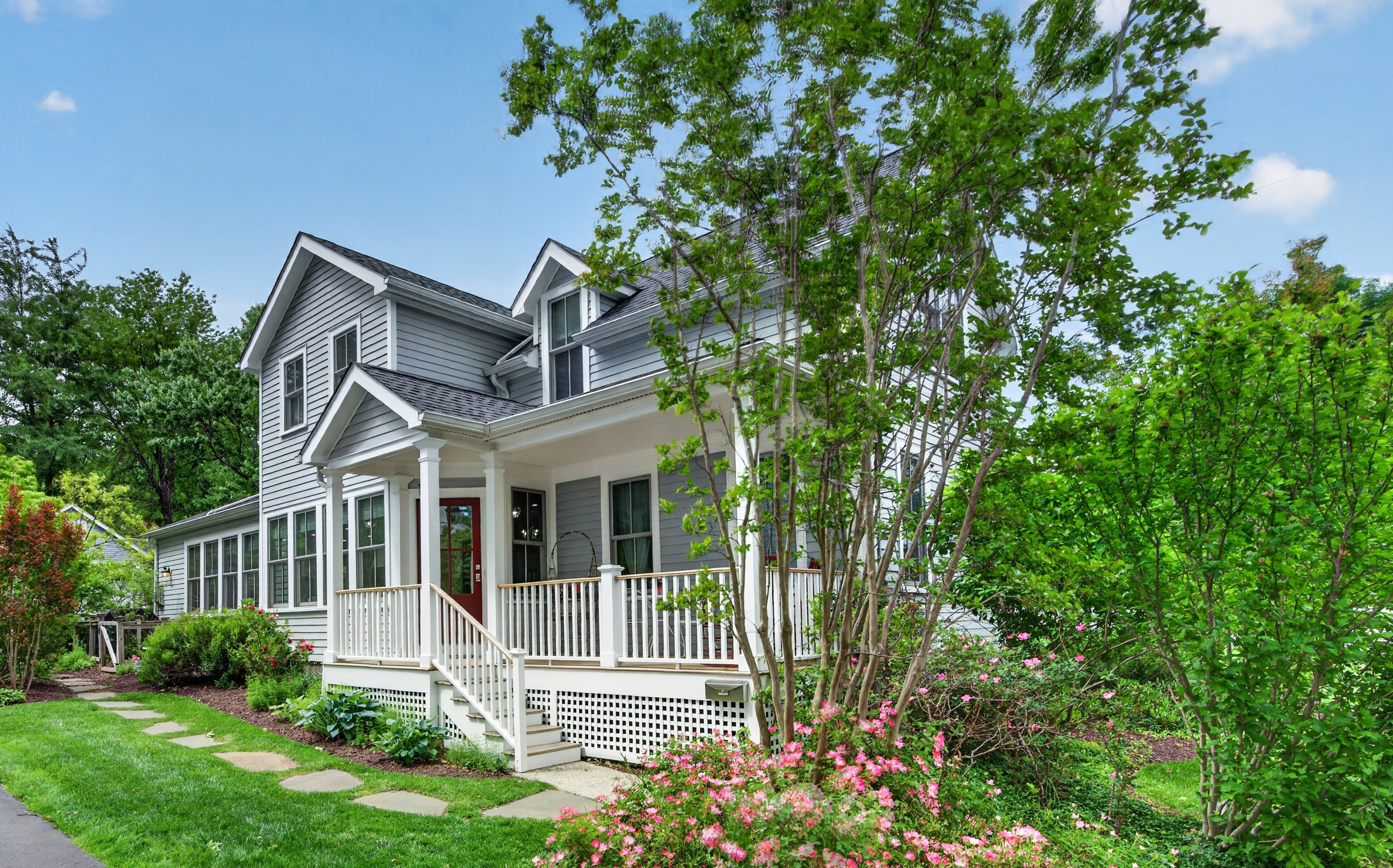 Front exterior view of the beautifully maintained custom colonial home at 89 Myrtle Avenue in Millburn, featuring a covered porch, classic architectural details, and a well-manicured front yard.