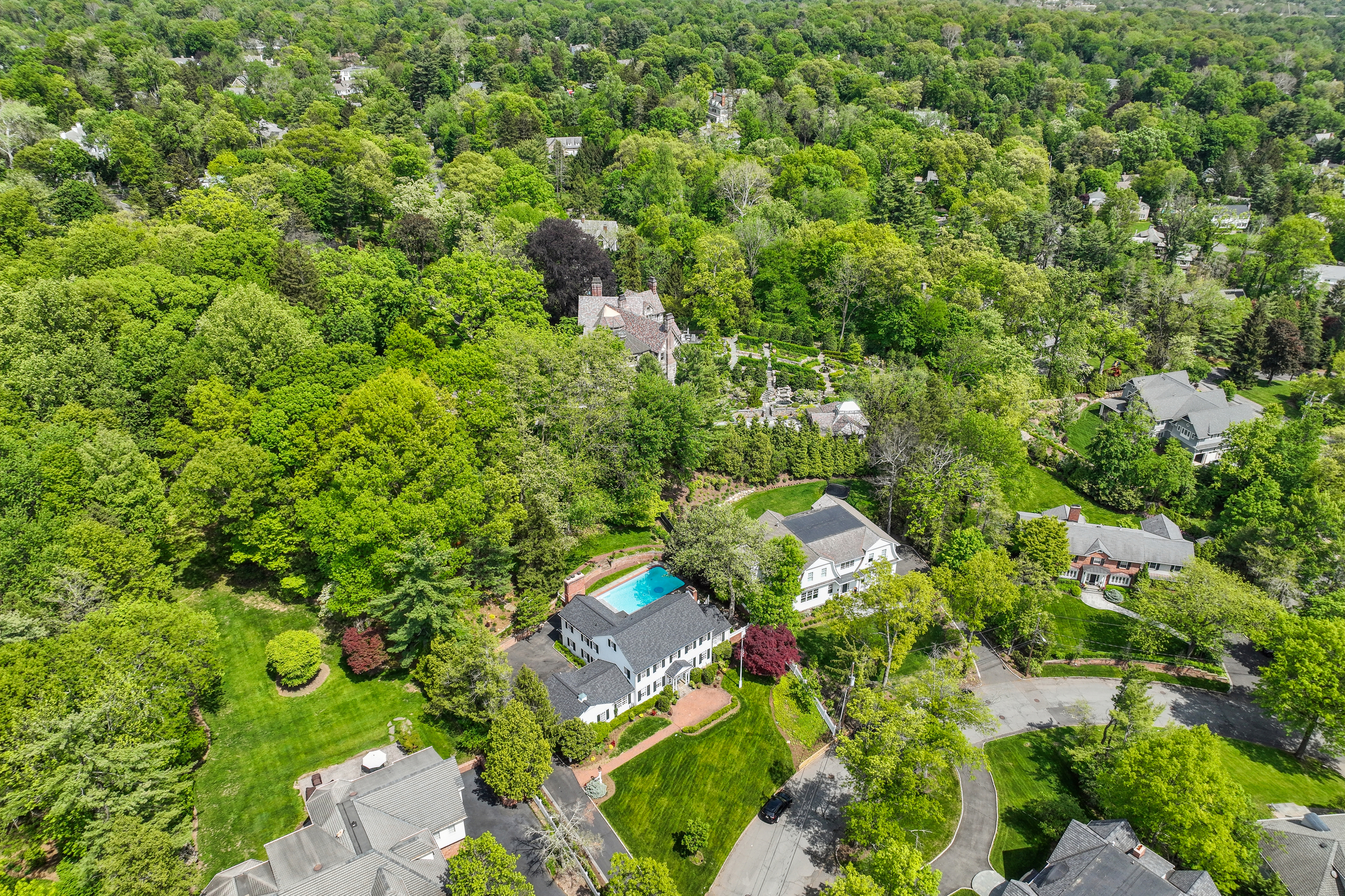 A collection of luxury homes showcasing a variety of features, including some with sparkling swimming pools and others without, illustrating the difference between must-have and nice-to-have amenities in a successful home search.