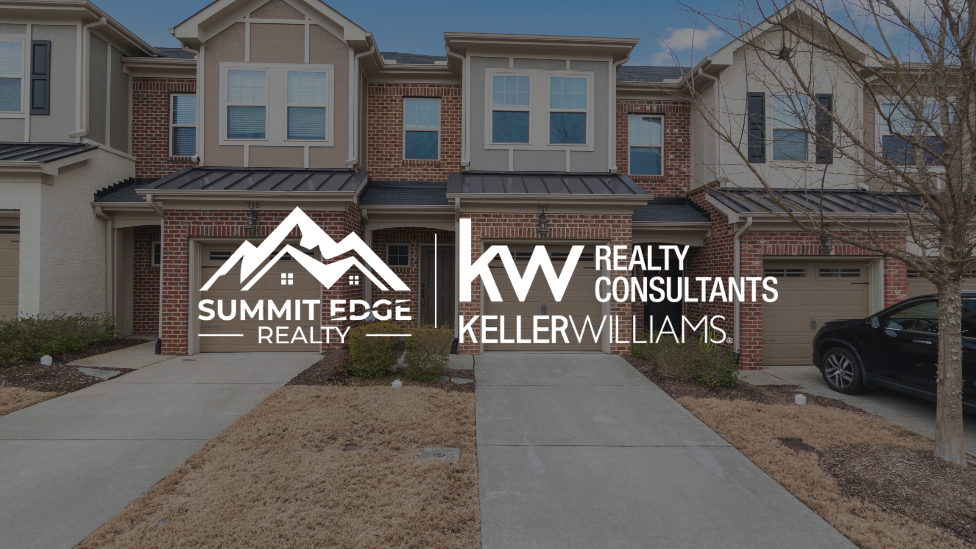 Exterior view of a multifamily houses in Floyd County, IN, with brick and beige exteriors, spacious windows, and a shared garden space with playground equipment, branded with the Summit Edge Realty and KW Realty Consultants Keller Williams logo in white.