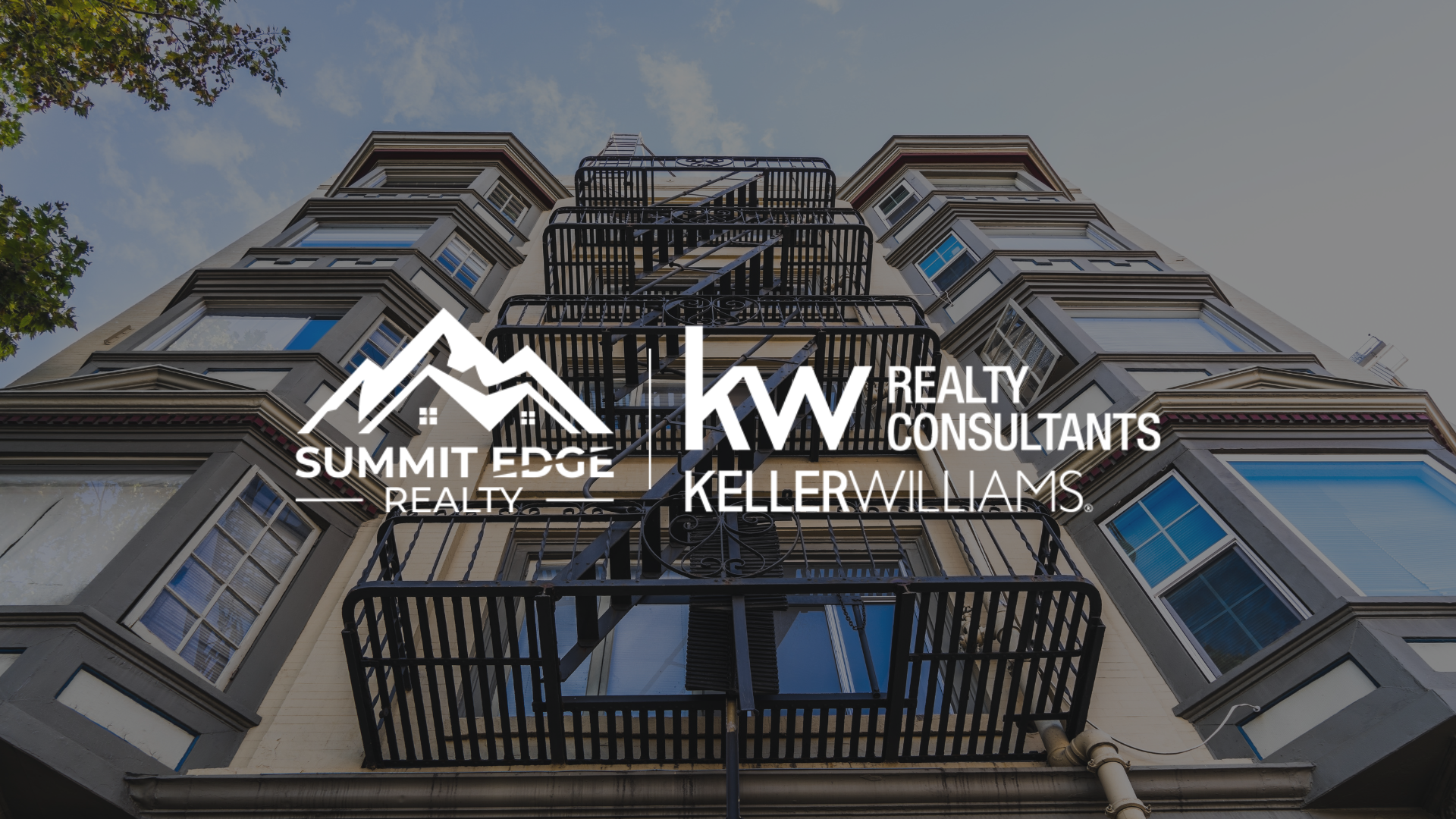 A Louisville, KY, multifamily residence with gray and beige facade, large windows, and black fire escapes, with trees nearby, overlaid with the Summit Edge Realty and KW Realty Consultants Keller Williams logo in white.