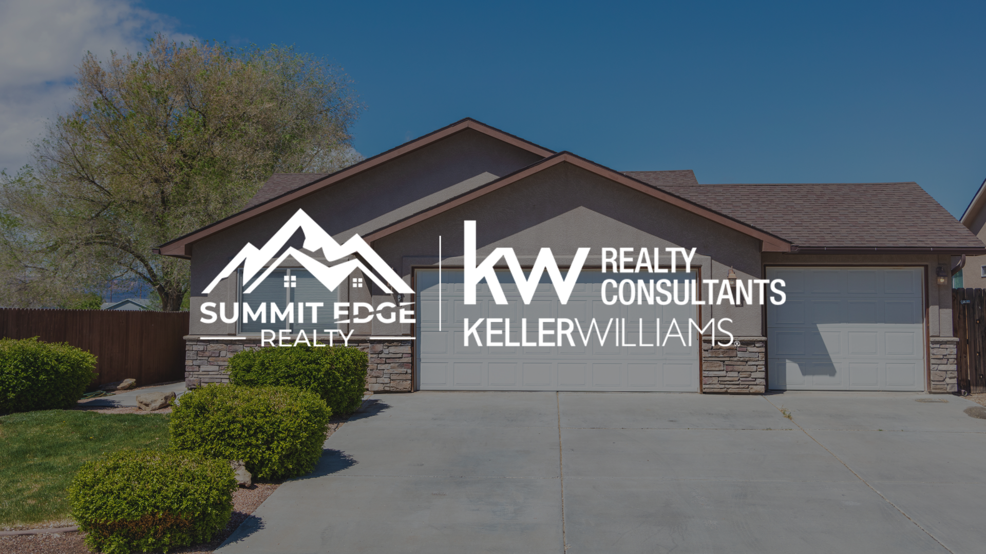 A suburban single family home with a gray exterior, stone accents, and a double garage, accompanied by the Summit Edge Realty and Keller Williams Realty Consultants logo in white.