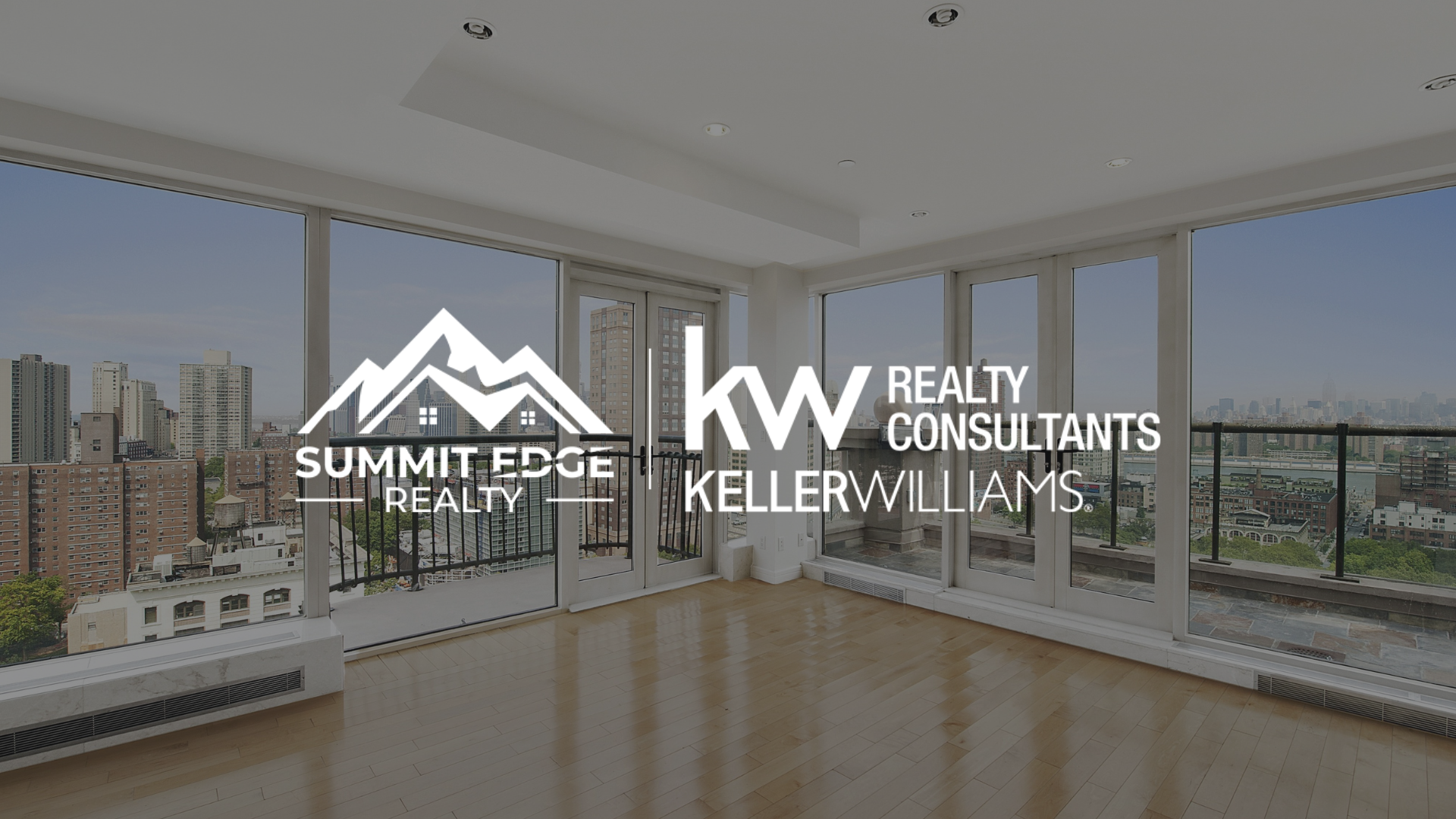 Condo living room with city view, with Summit Edge Realty logo in the foreground.