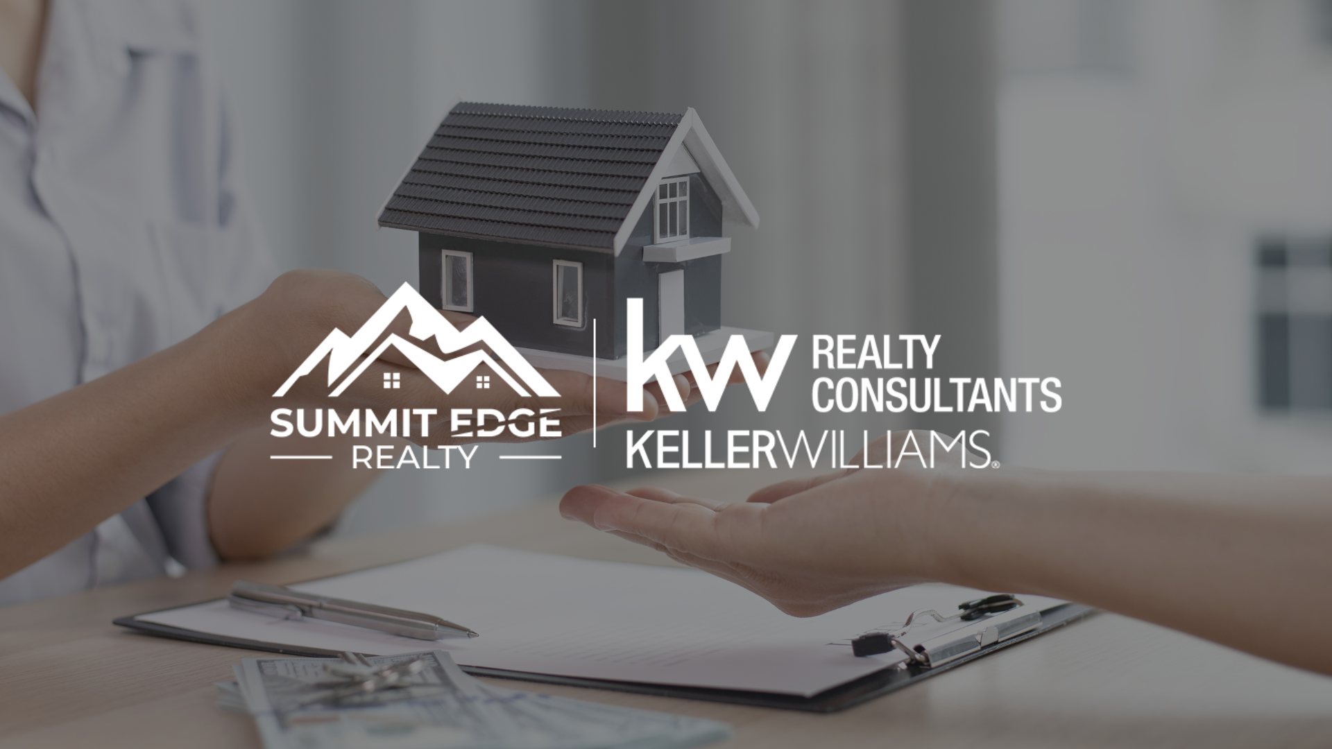 Hands exchanging a miniature manufactured house model during a real estate meeting in Louisville, KY, with a clipboard, pen, and currency on the table, signifying the home-buying journey, displaying the Summit Edge Realty and KW Realty Consultants Keller Williams logo in white.