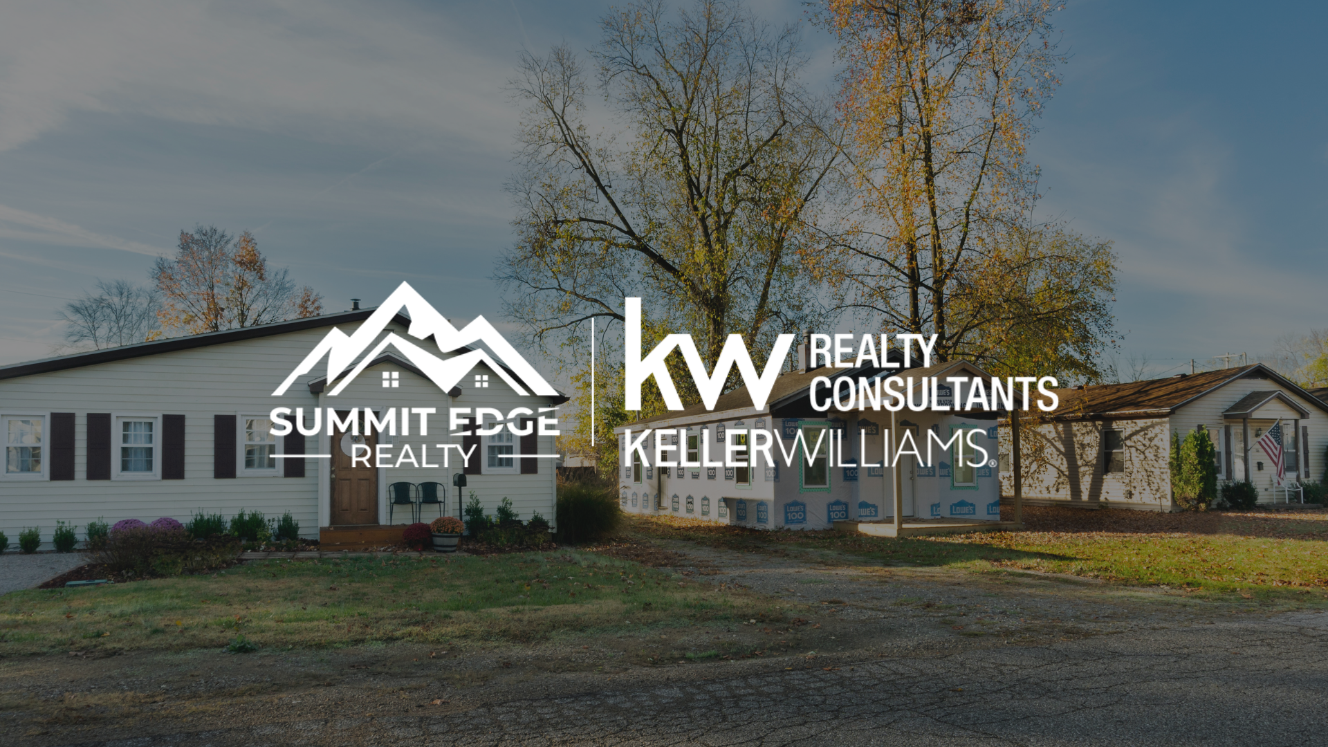 A single family home with a white exterior and wooden door, surrounded by a spacious lawn and autumn trees, featuring the Summit Edge Realty and Keller Williams Realty Consultants logo in the foreground.