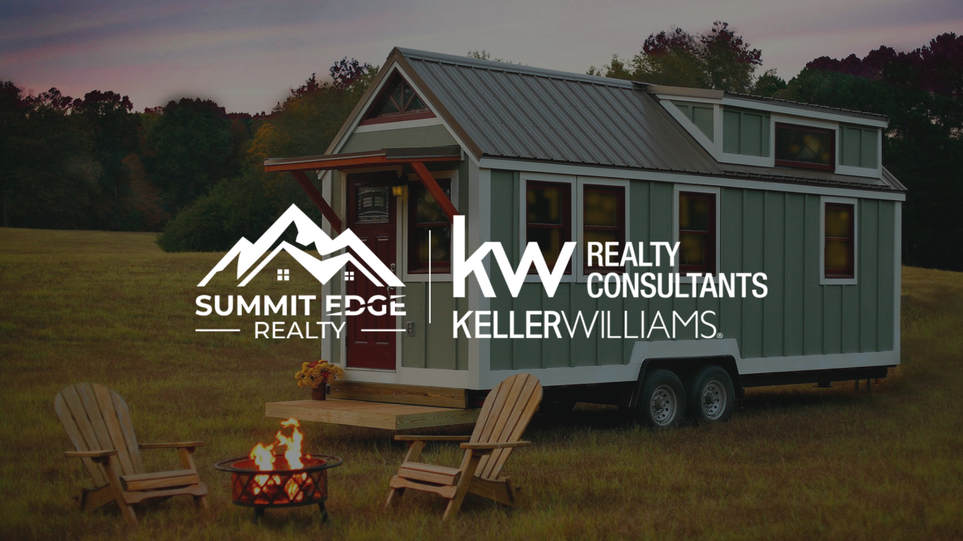 A cozy tiny home in Harrison County, Indiana, with a beige wooden exterior, a slanted gray roof, and a small window with shutters, featuring a stone pathway leading to the entrance, set against a backdrop of rolling hills and trees under a clear sky, overlaid with the Summit Edge Realty and KW Realty Consultants Keller Williams logo in white text.