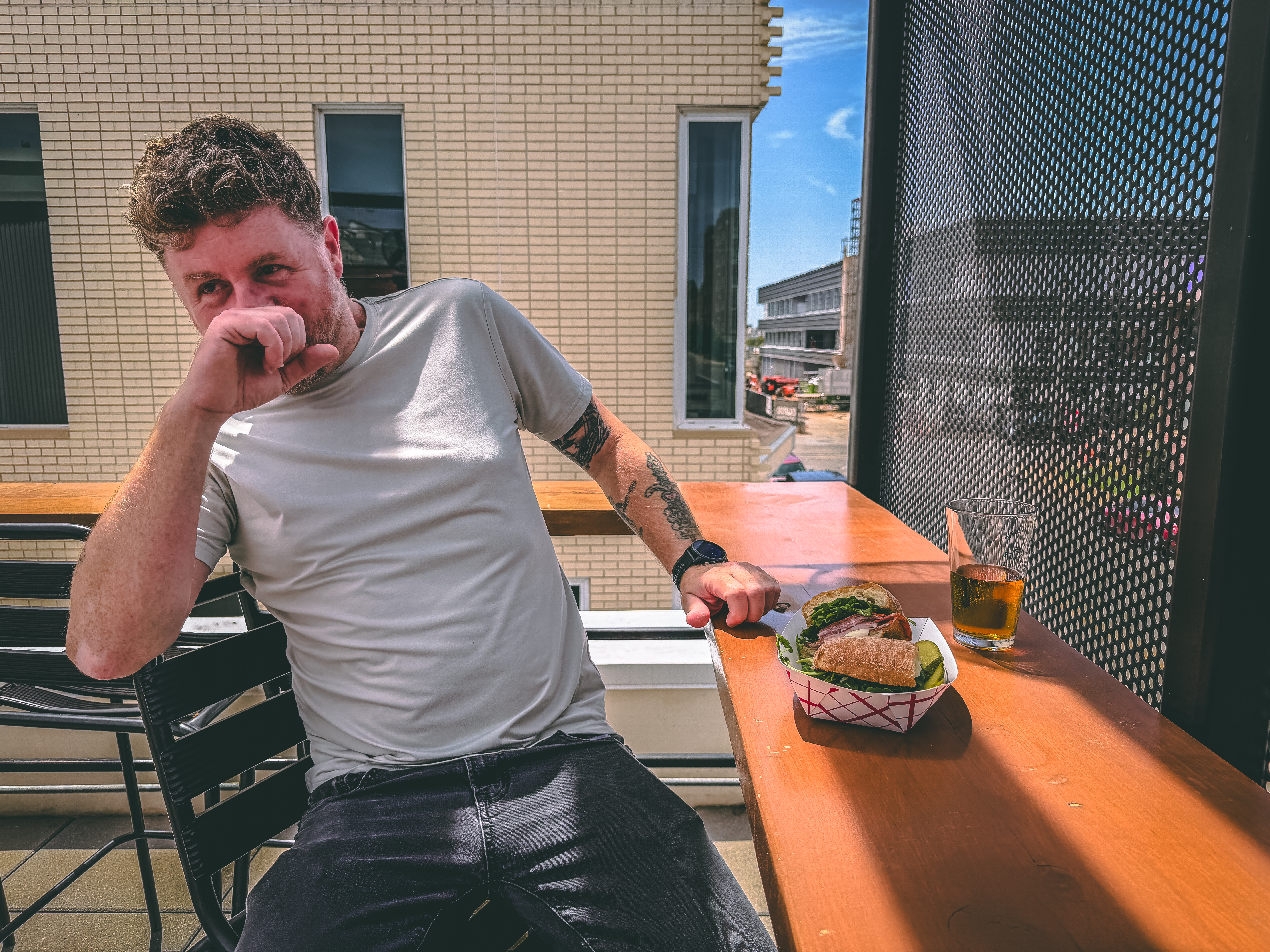 Jerod sits on The Goose patio with his food