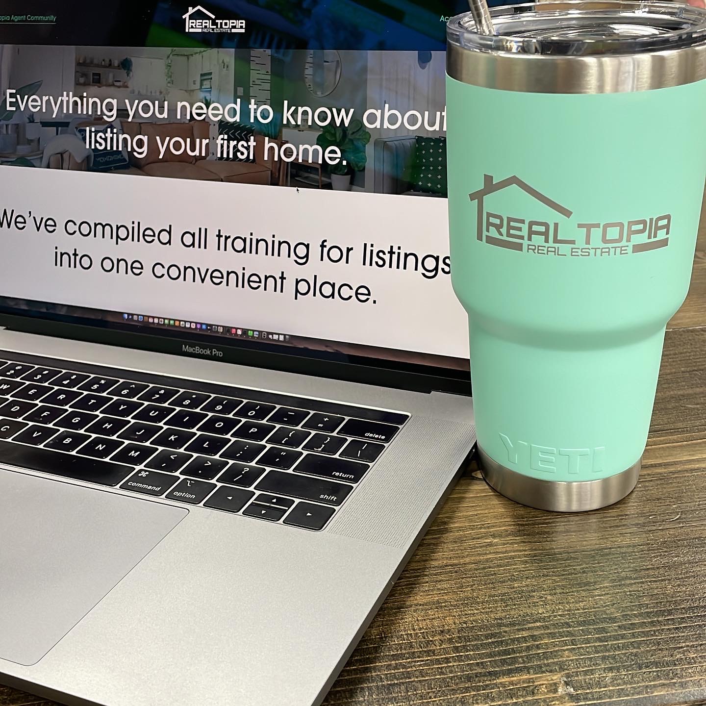 Realtopia Real Estate teal mug with laptop open to training website for agents