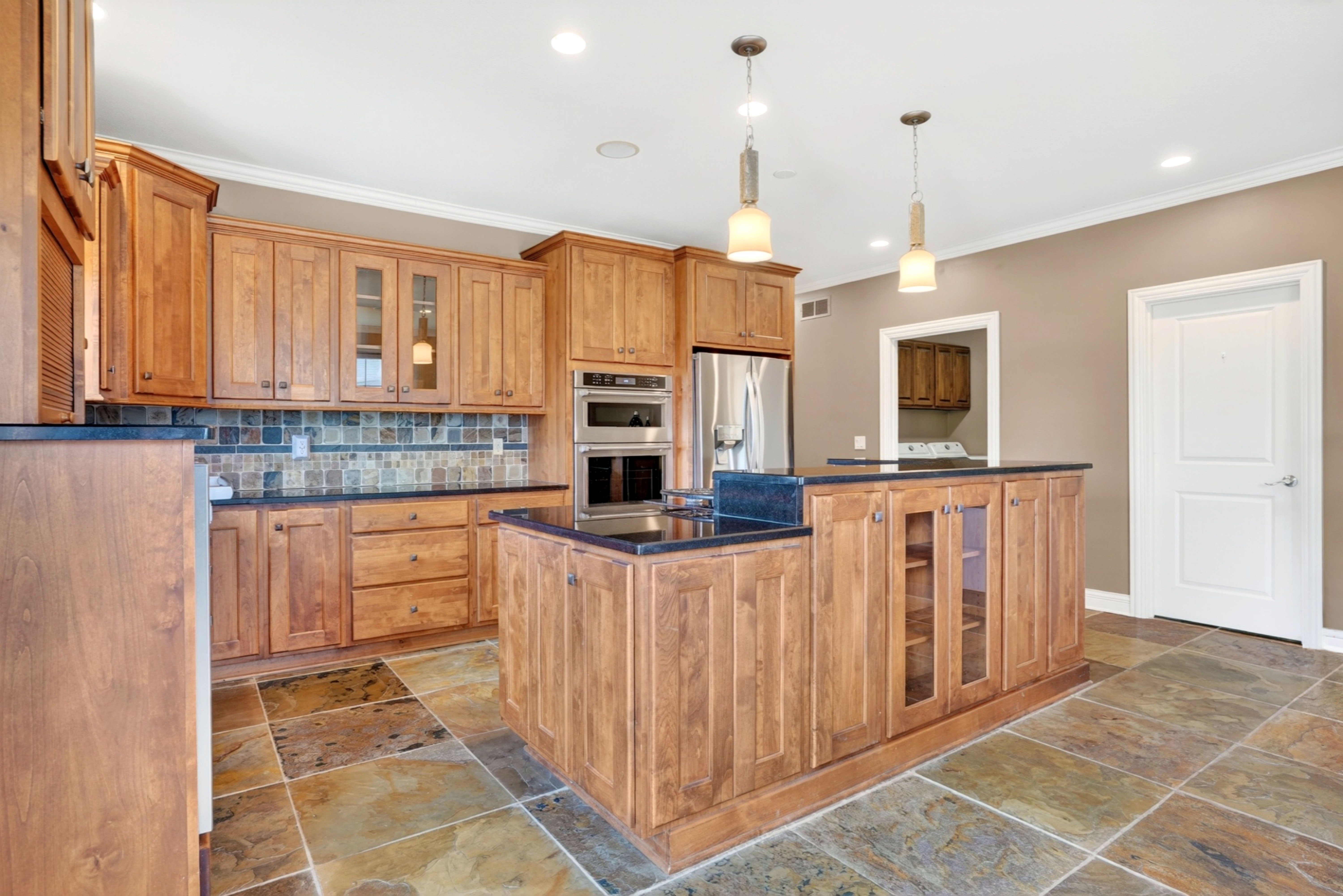 Kitchen with wood cabinetry and stone flooring in a Columbia, MO home