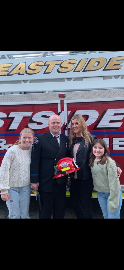 family of 4 in front of a firetruck 